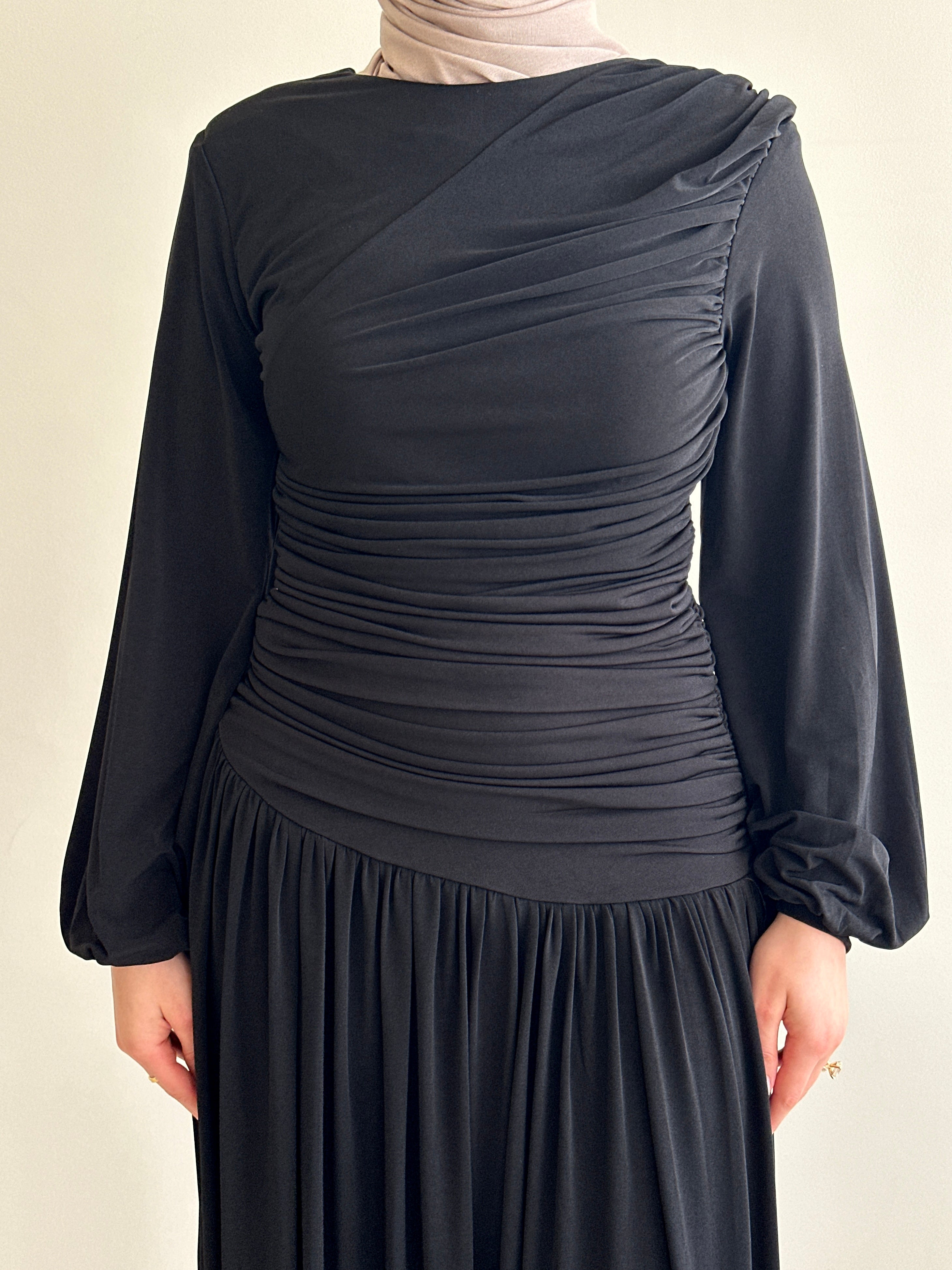 women's maxi jersey dress in brown and black. It has ruching detailing, long sleeves and is maxi for hijabis, it's modest and suitable to wear for dinner, occasions, eid, etc.