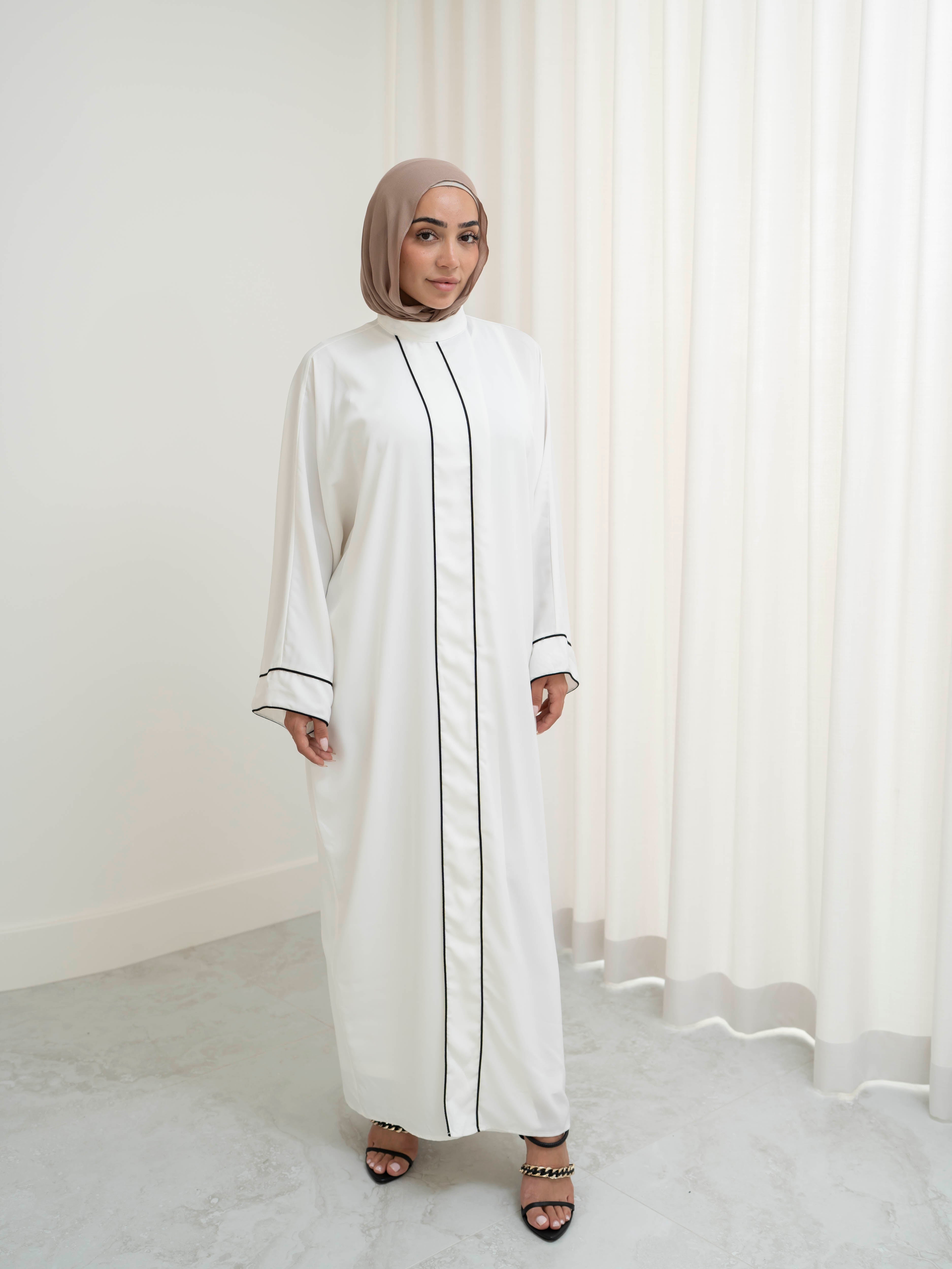 Model wearing the Noor Line abaya featuring a clean silhouette with subtle line detailing, styled for a modest and elegant look suitable for Ramadan and Eid.