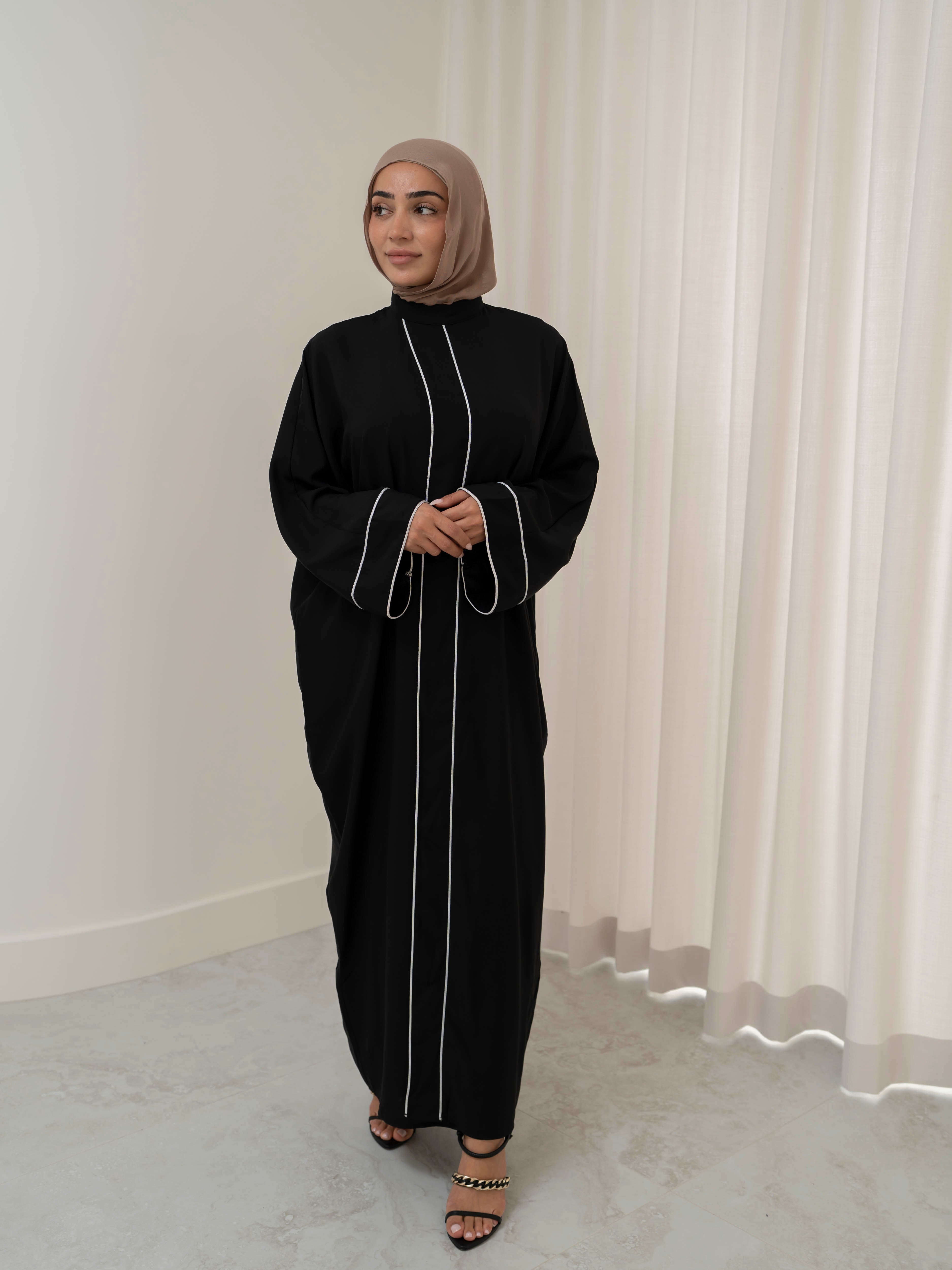 Model wearing the Noor Line abaya featuring a clean silhouette with subtle line detailing, styled for a modest and elegant look suitable for Ramadan and Eid.