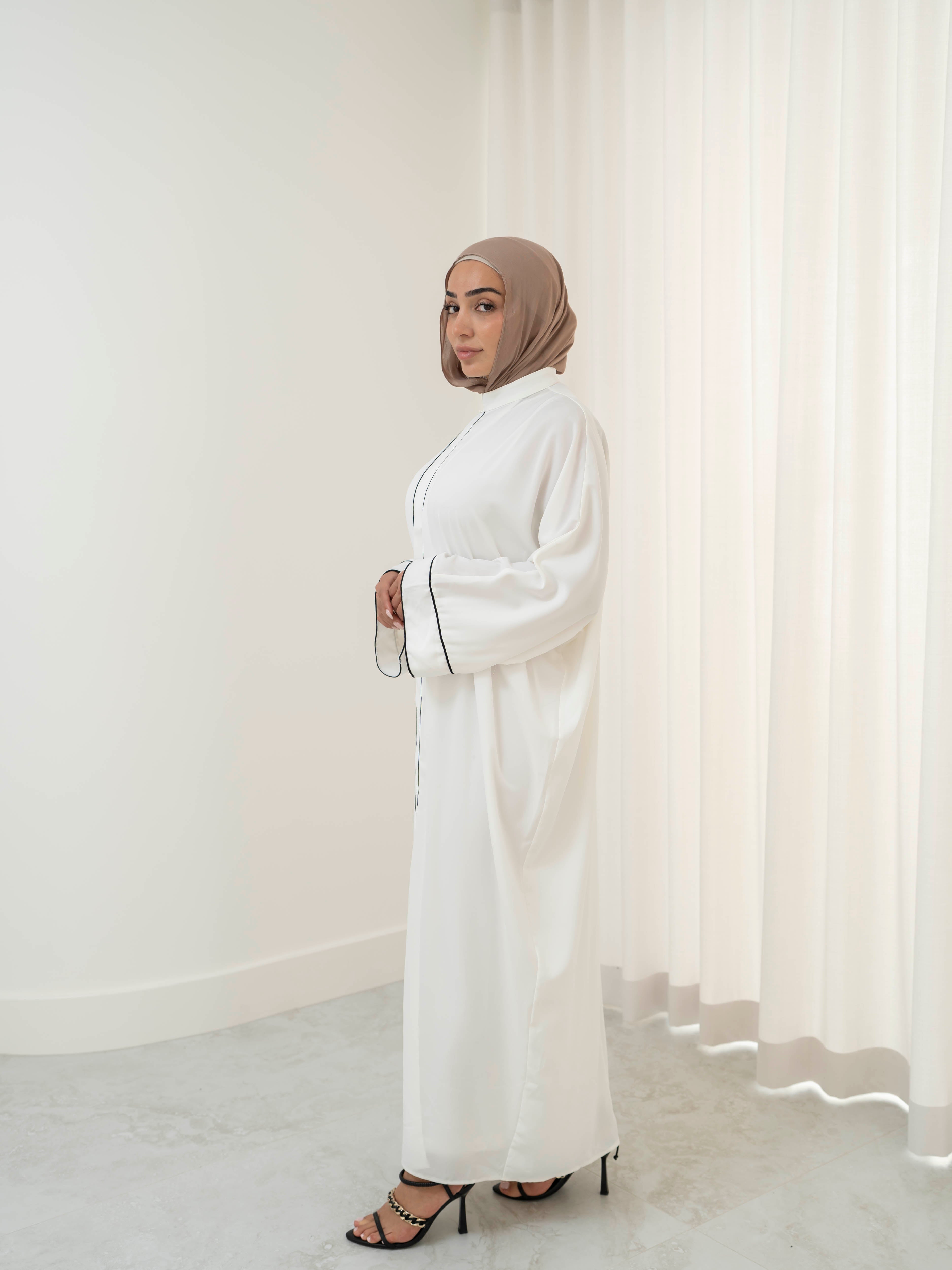 Model wearing the Noor Line abaya featuring a clean silhouette with subtle line detailing, styled for a modest and elegant look suitable for Ramadan and Eid.