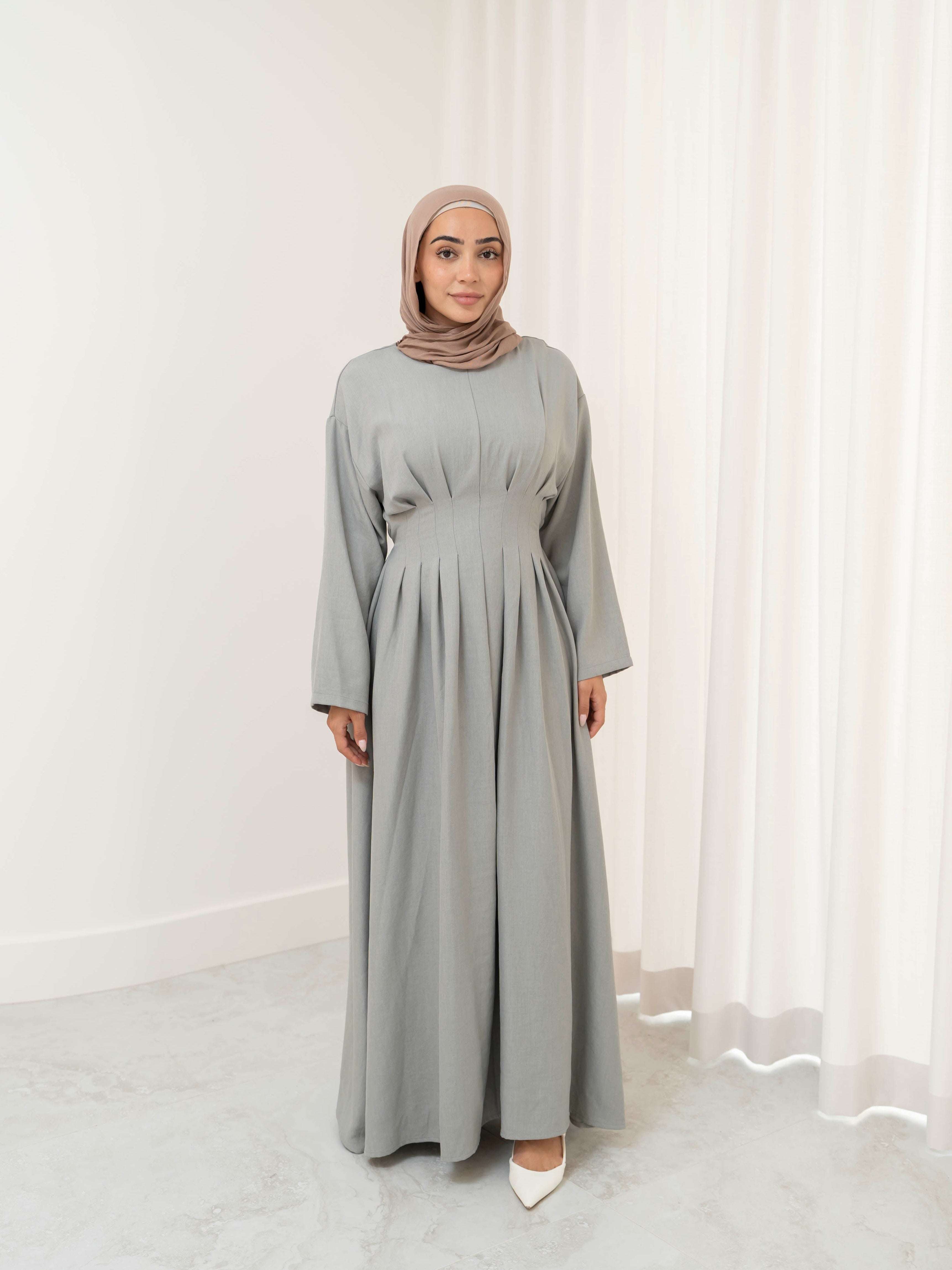 Model wearing the Safa pleated dress featuring a flowing silhouette with soft pleat detailing, styled for a modest and elegant look suitable for Ramadan and Eid.