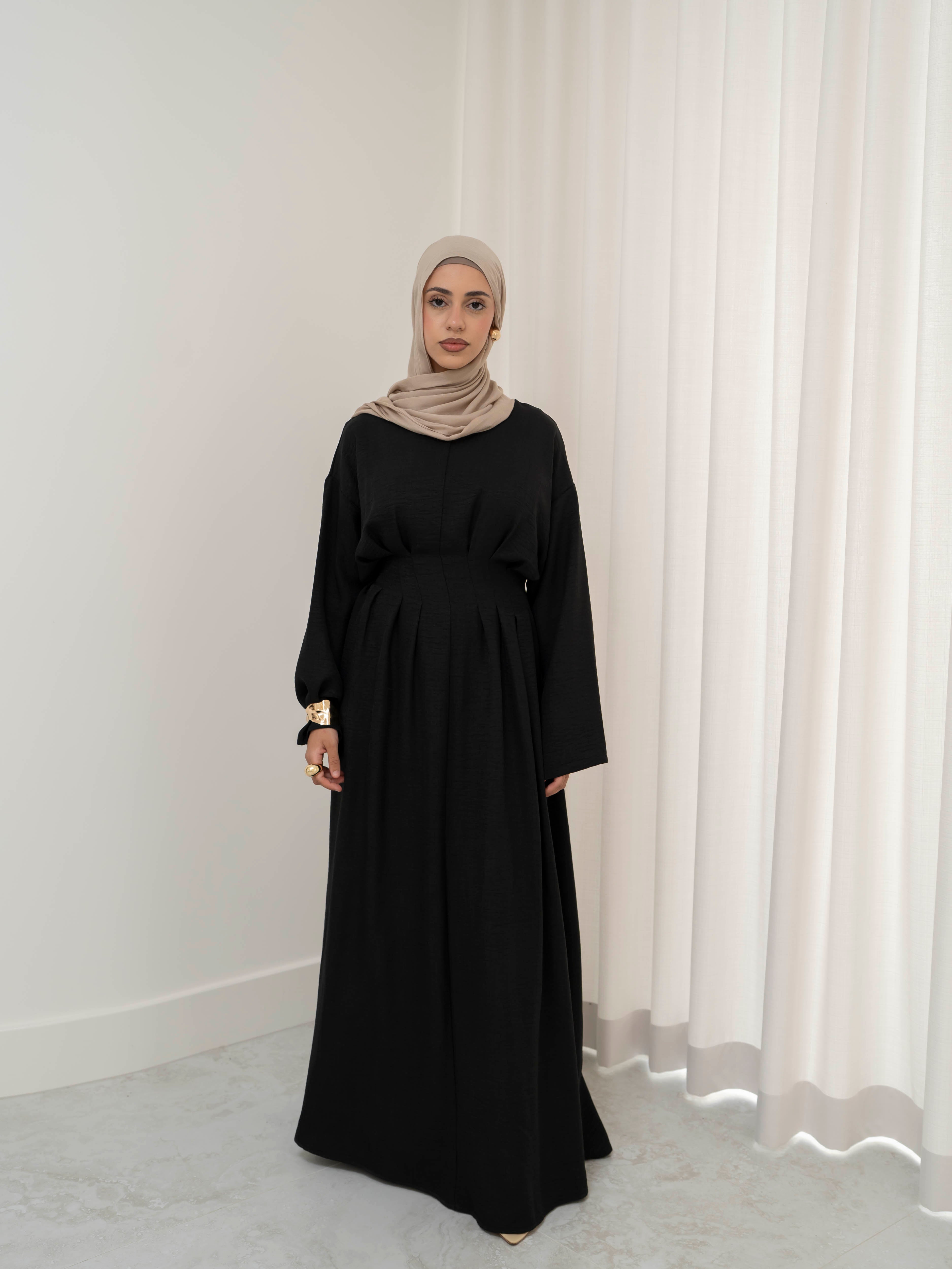 Model wearing the Safa pleated dress featuring a flowing silhouette with soft pleat detailing, styled for a modest and elegant look suitable for Ramadan and Eid.