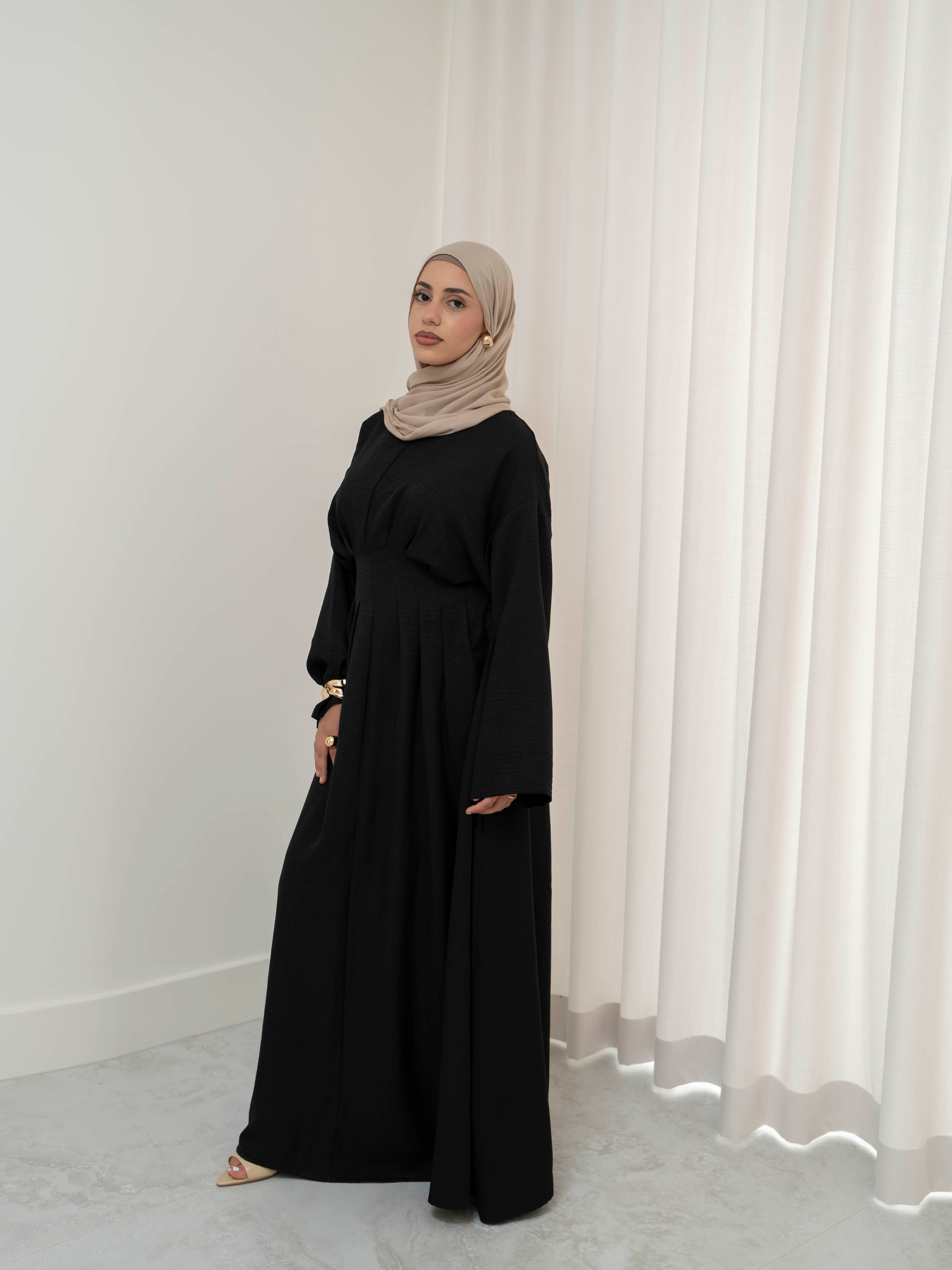 Model wearing the Safa pleated dress featuring a flowing silhouette with soft pleat detailing, styled for a modest and elegant look suitable for Ramadan and Eid.