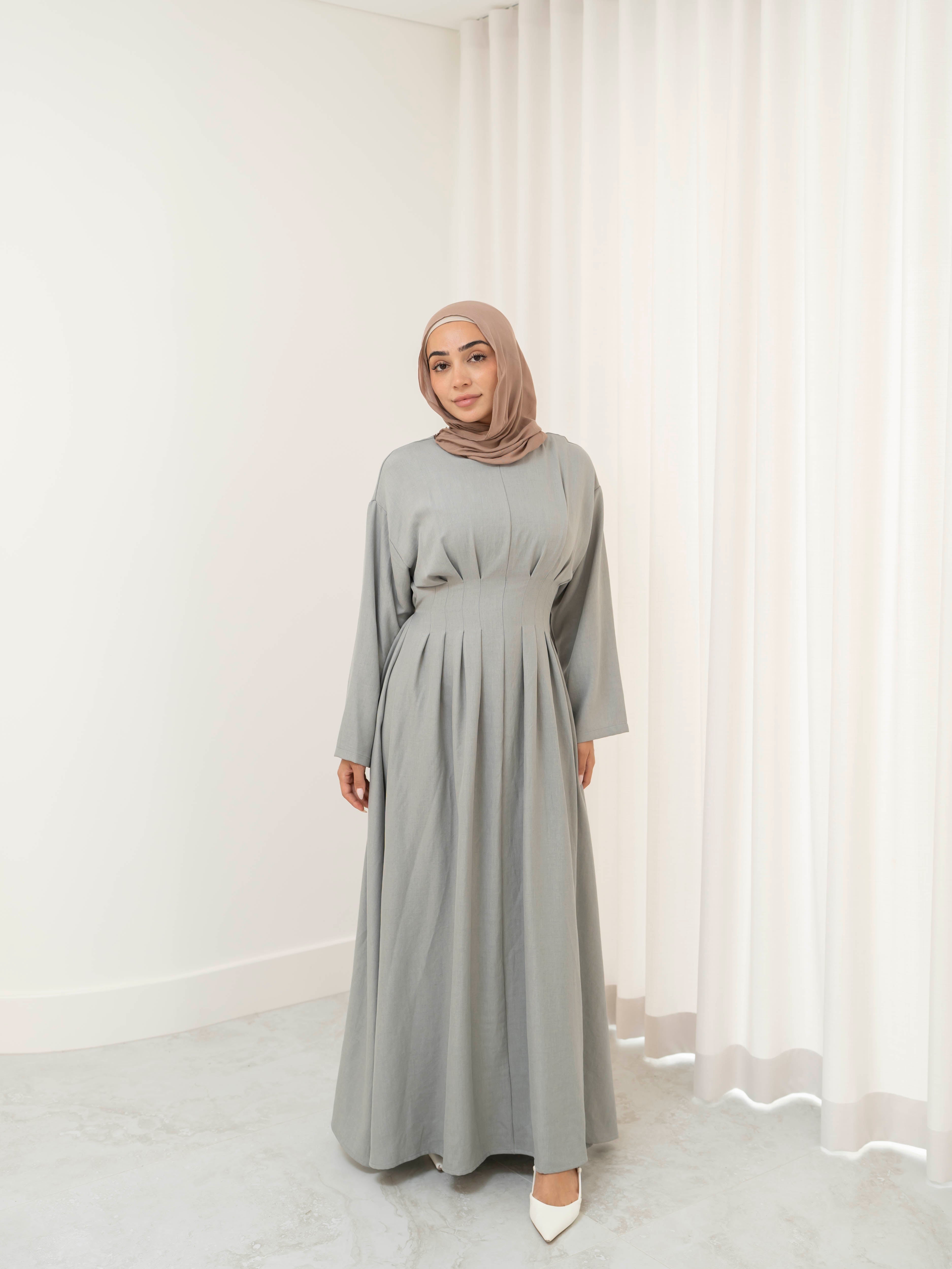 Model wearing the Safa pleated dress featuring a flowing silhouette with soft pleat detailing, styled for a modest and elegant look suitable for Ramadan and Eid.