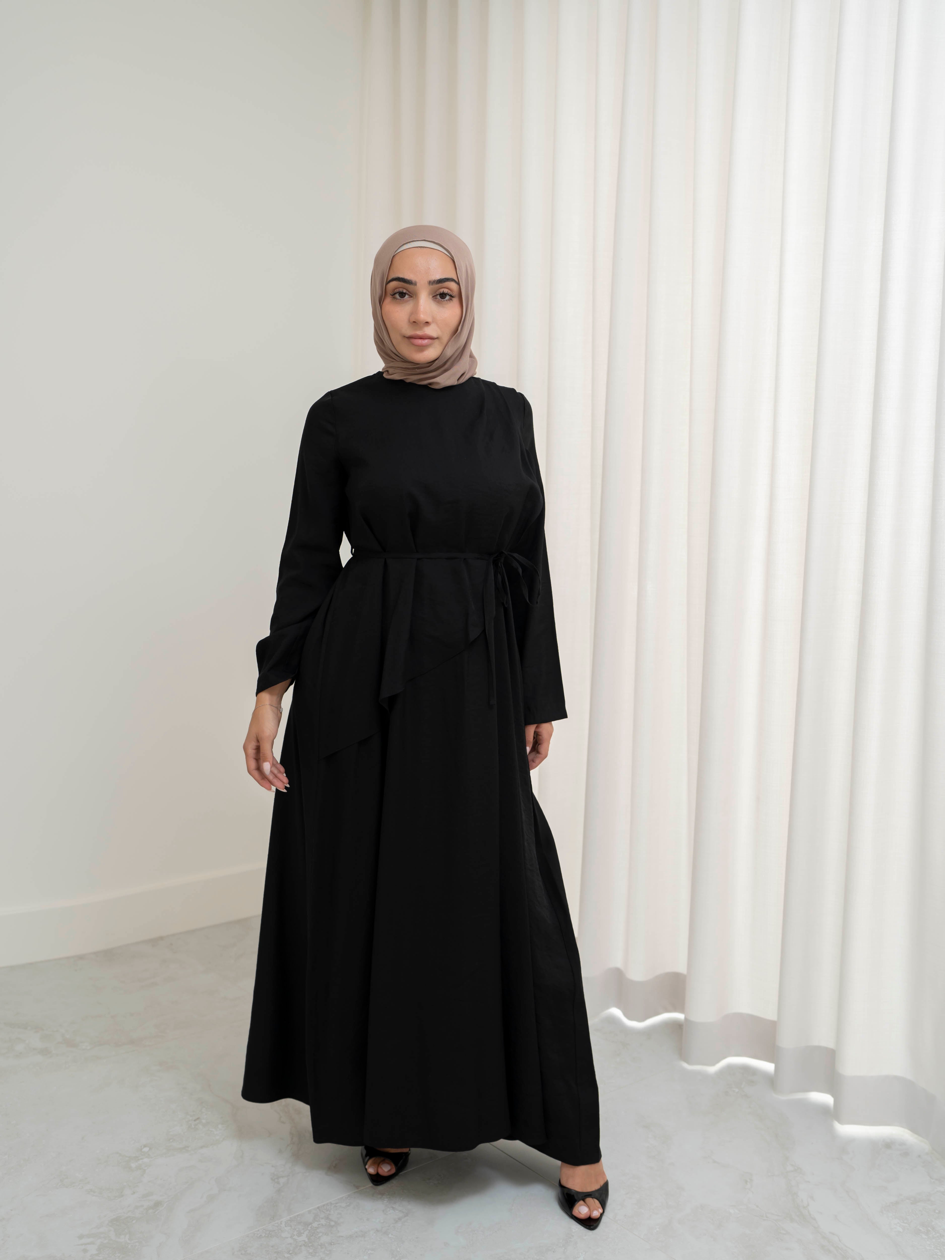 Model wearing the Kareema A-line tie waist dress featuring a flowing silhouette and waist tie detail, styled for a modest and elegant look suitable for Ramadan and Eid.