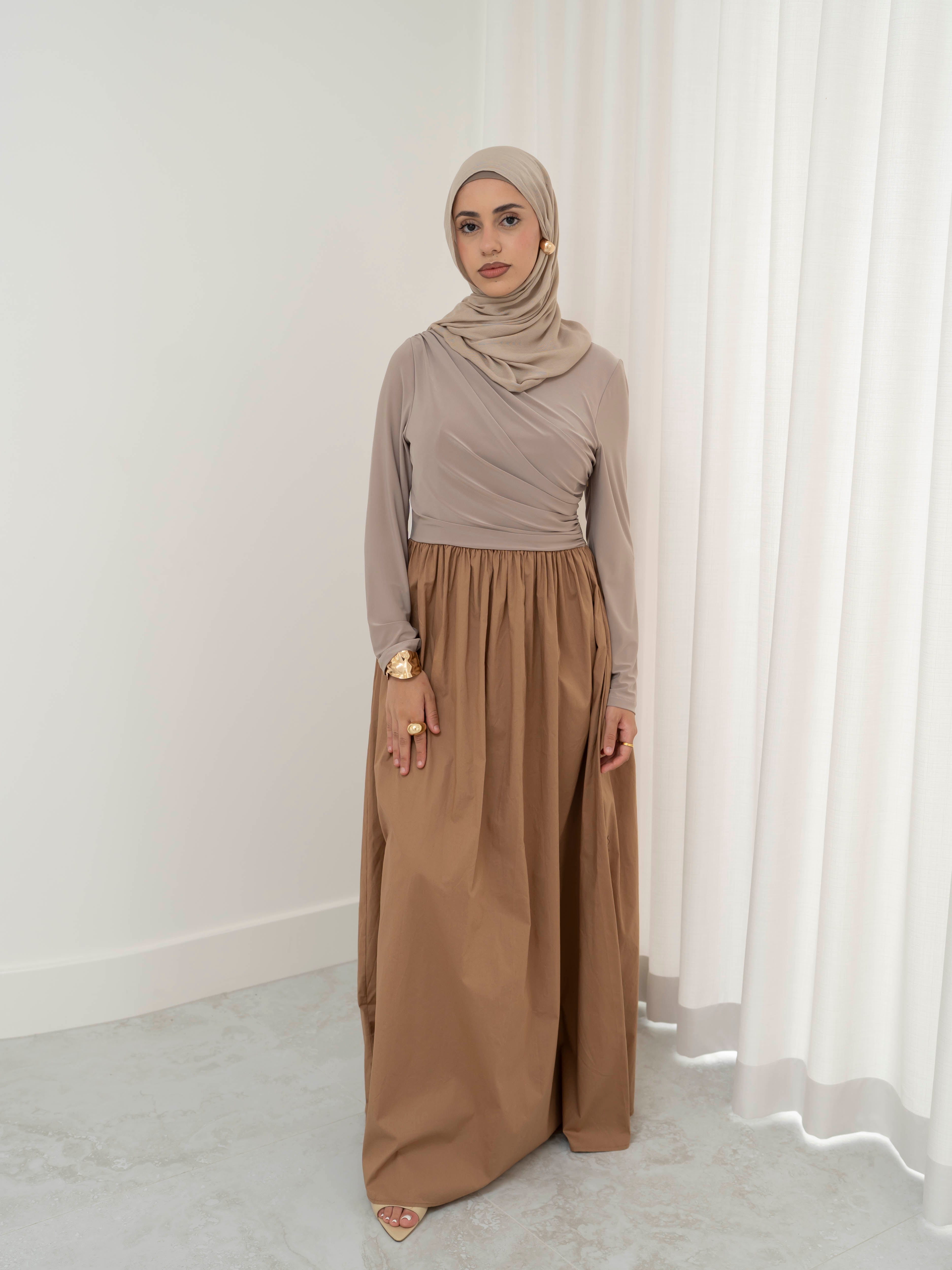 Model wearing the Aicha gathered dress featuring a jersey bodice and poplin skirt with soft gathered detailing, styled for a modest and elegant look suitable for Ramadan and Eid.