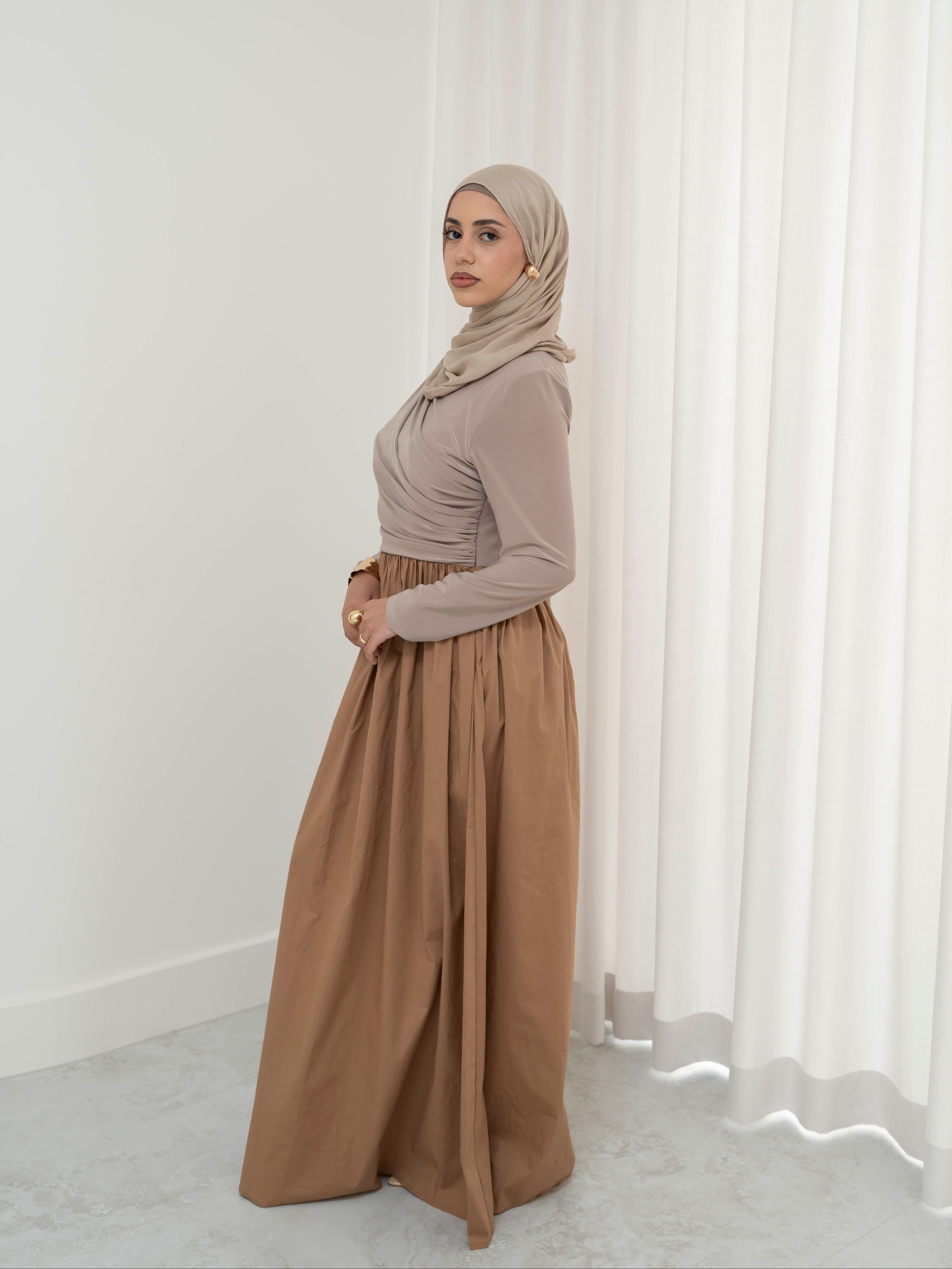 Model wearing the Aicha gathered dress featuring a jersey bodice and poplin skirt with soft gathered detailing, styled for a modest and elegant look suitable for Ramadan and Eid.