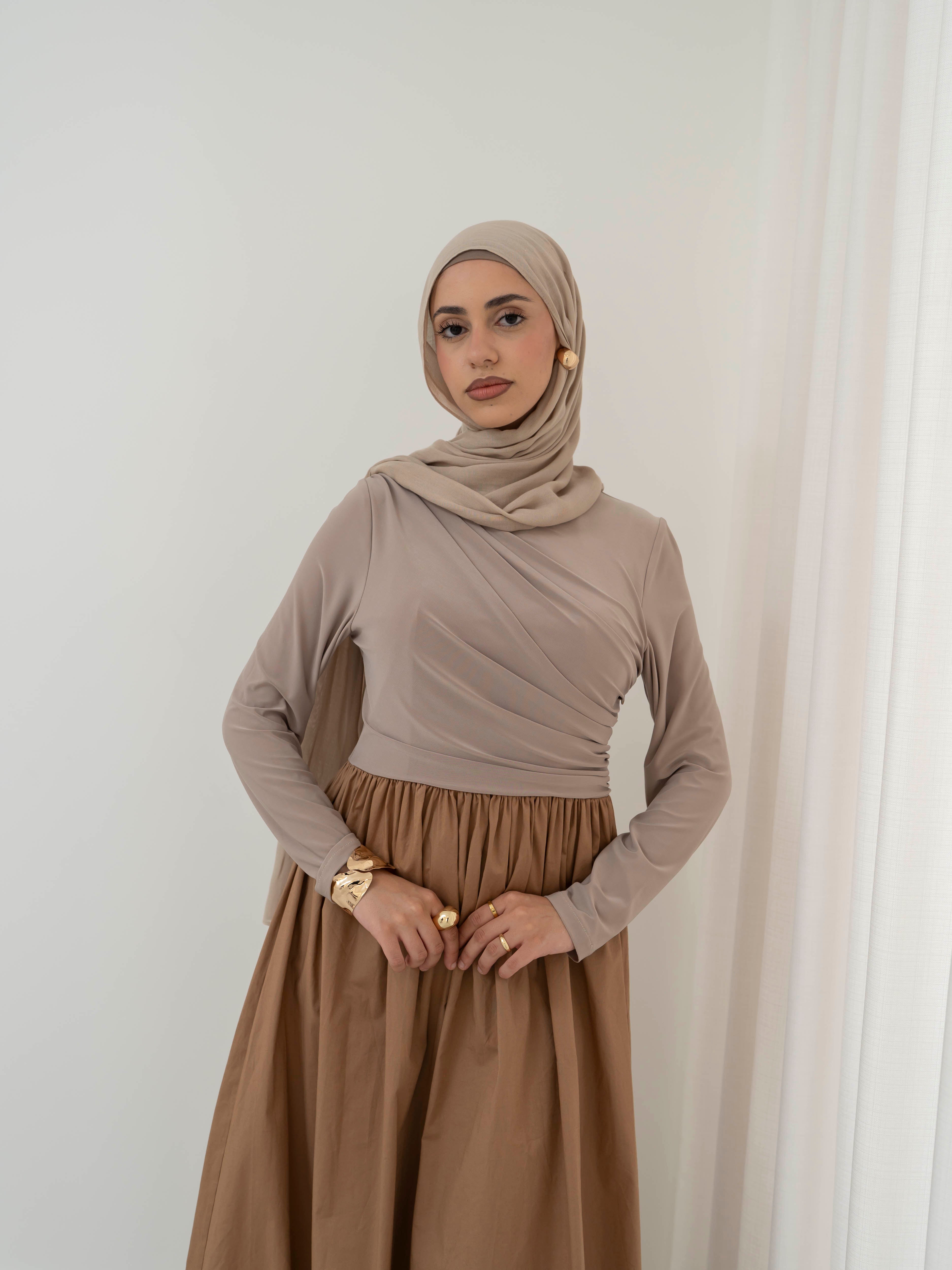 Model wearing the Aicha gathered dress featuring a jersey bodice and poplin skirt with soft gathered detailing, styled for a modest and elegant look suitable for Ramadan and Eid.