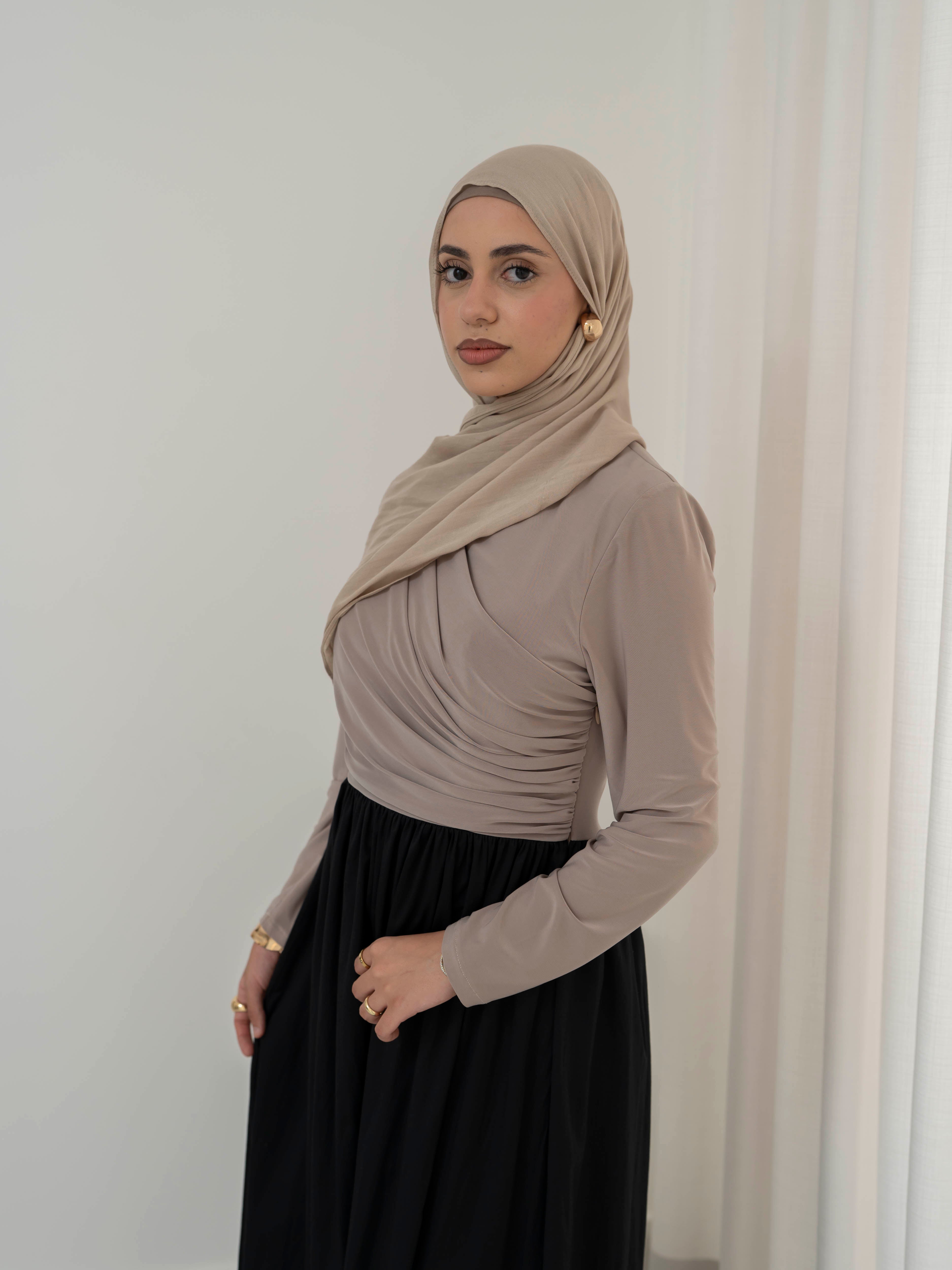 Model wearing the Aicha gathered dress featuring a jersey bodice and poplin skirt with soft gathered detailing, styled for a modest and elegant look suitable for Ramadan and Eid.