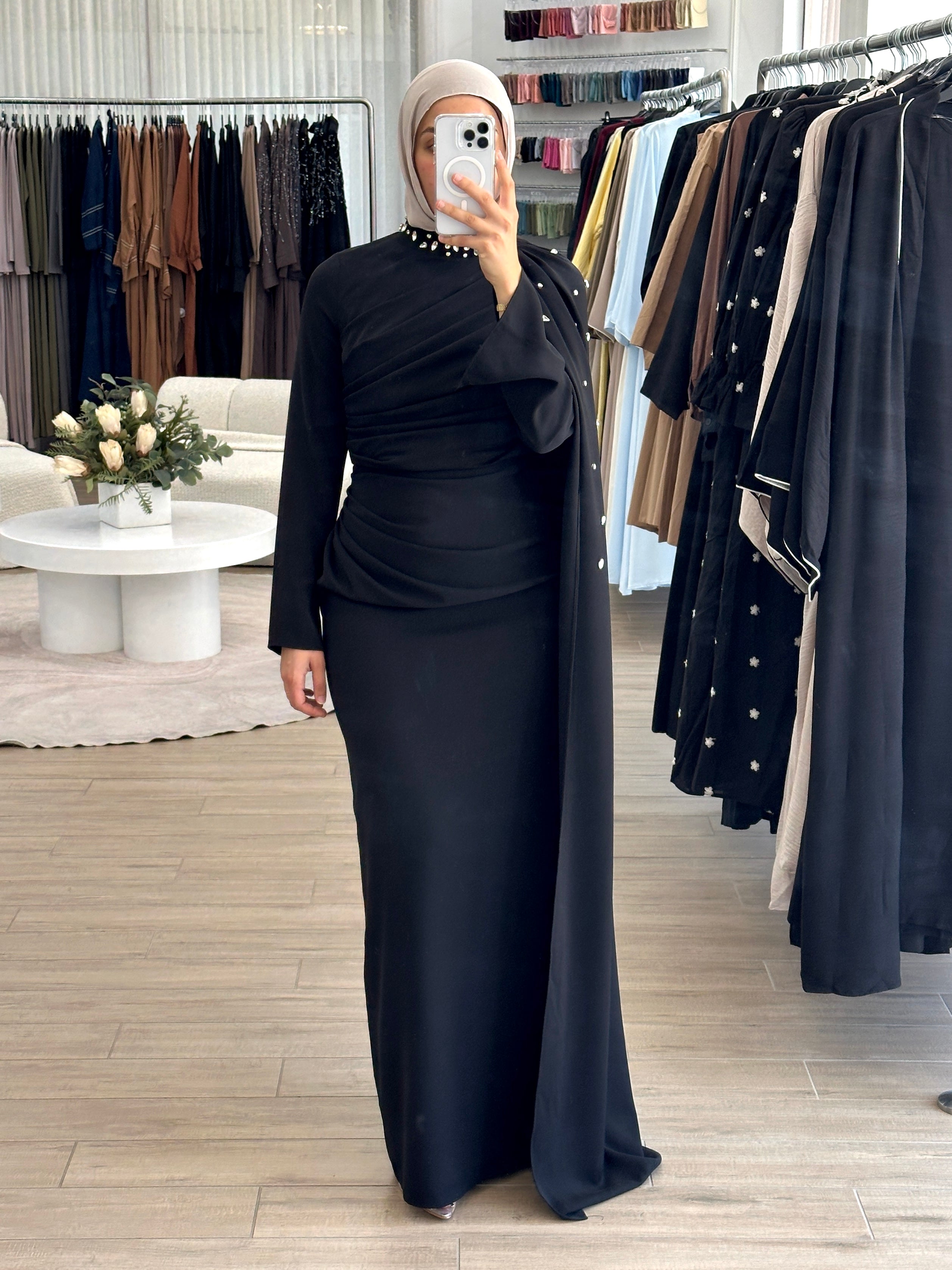 women's full length maxi formal dress in black with minimal jewel embellishment. Dress is fitted on the waist with ruching and a cape that drapes off the shoulders. elegant to wear to any event/ occasion, suitable for hijabis.
