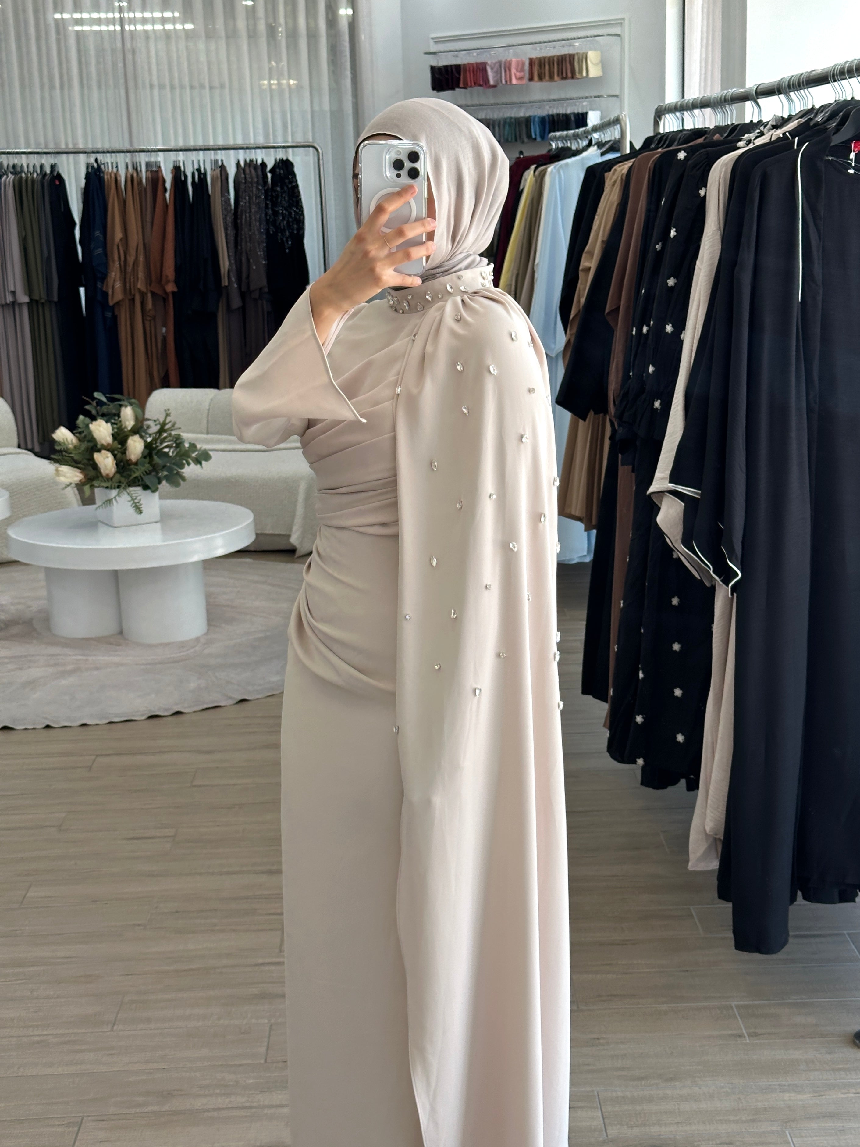 women's full length maxi formal dress in nude with minimal jewel embellishment. Dress is fitted on the waist with ruching and a cape that drapes off the shoulders. elegant to wear to any event/ occasion, suitable for hijabis.