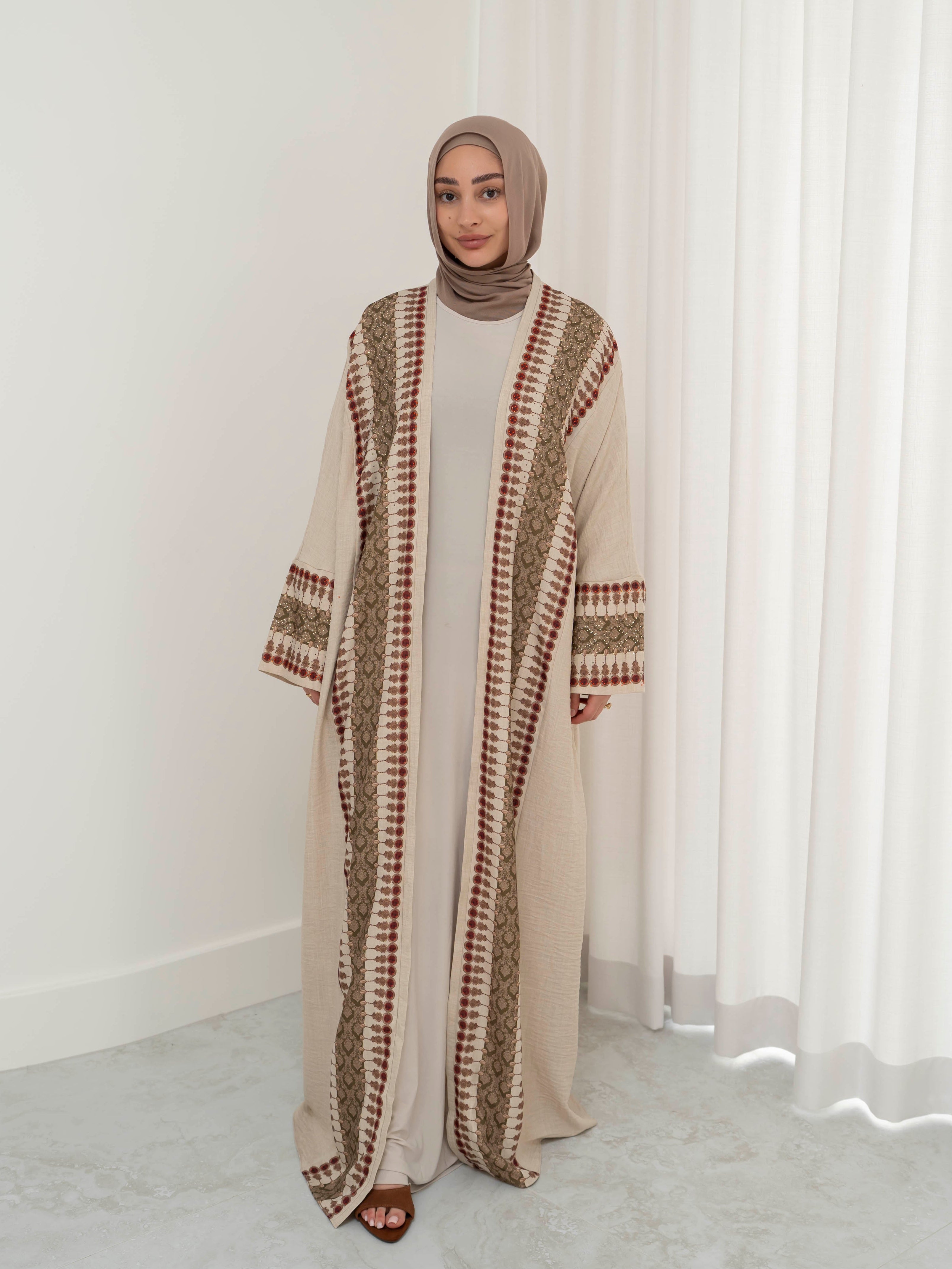 Model wearing the Andalus open abaya with an intricate patterned fabric and subtle embellishments, styled open for a modest and elegant look suitable for Ramadan and Eid.
