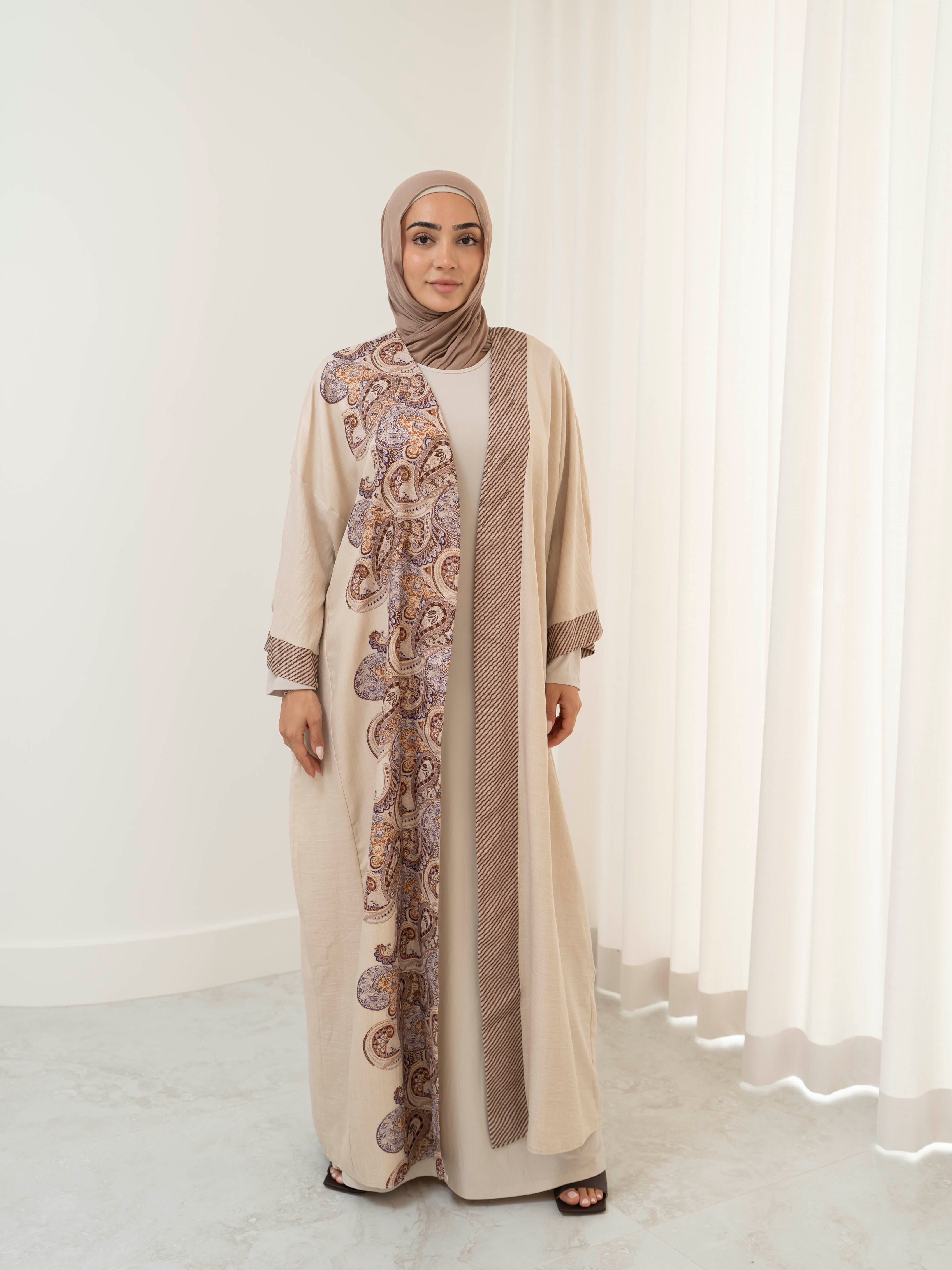Model wearing the Marwa open abaya featuring a flowing silhouette with fine embellishment detailing, styled open for a modest and elegant look suitable for Ramadan and Eid.