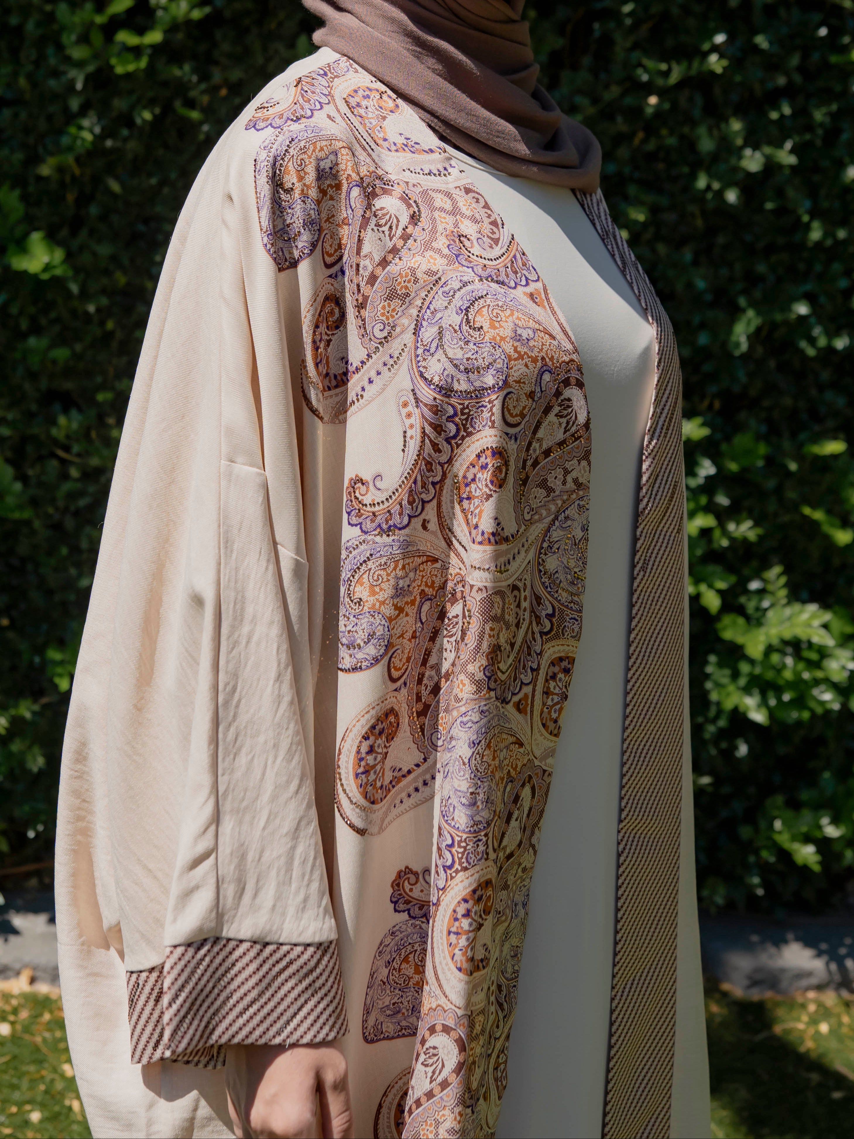 Model wearing the Marwa open abaya featuring a flowing silhouette with fine embellishment detailing, styled open for a modest and elegant look suitable for Ramadan and Eid.