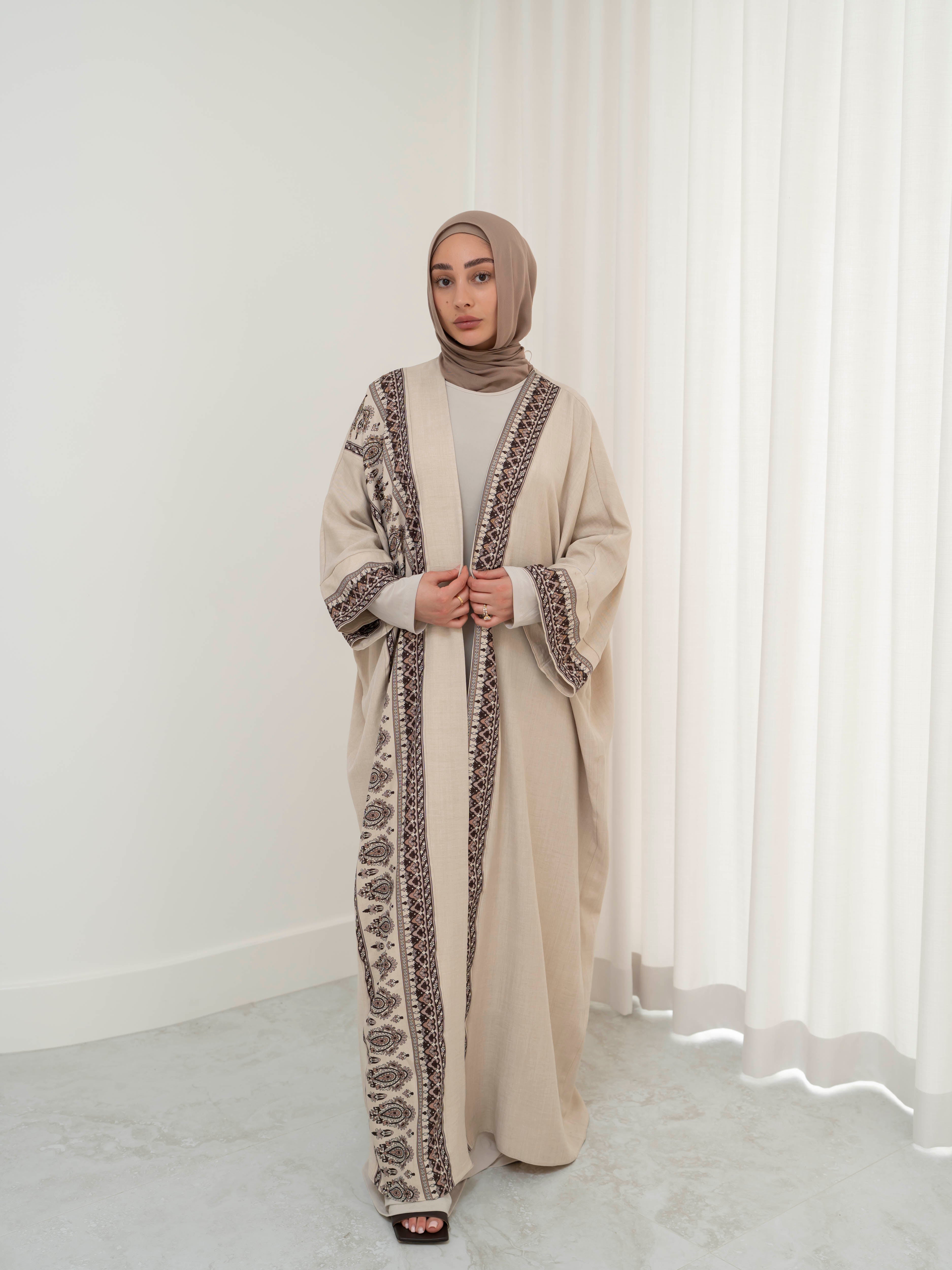 Model wearing the Safiya open abaya featuring a subtle patterned fabric and delicate embellishments, styled open for a modest and elegant look suitable for Ramadan and Eid occasions.