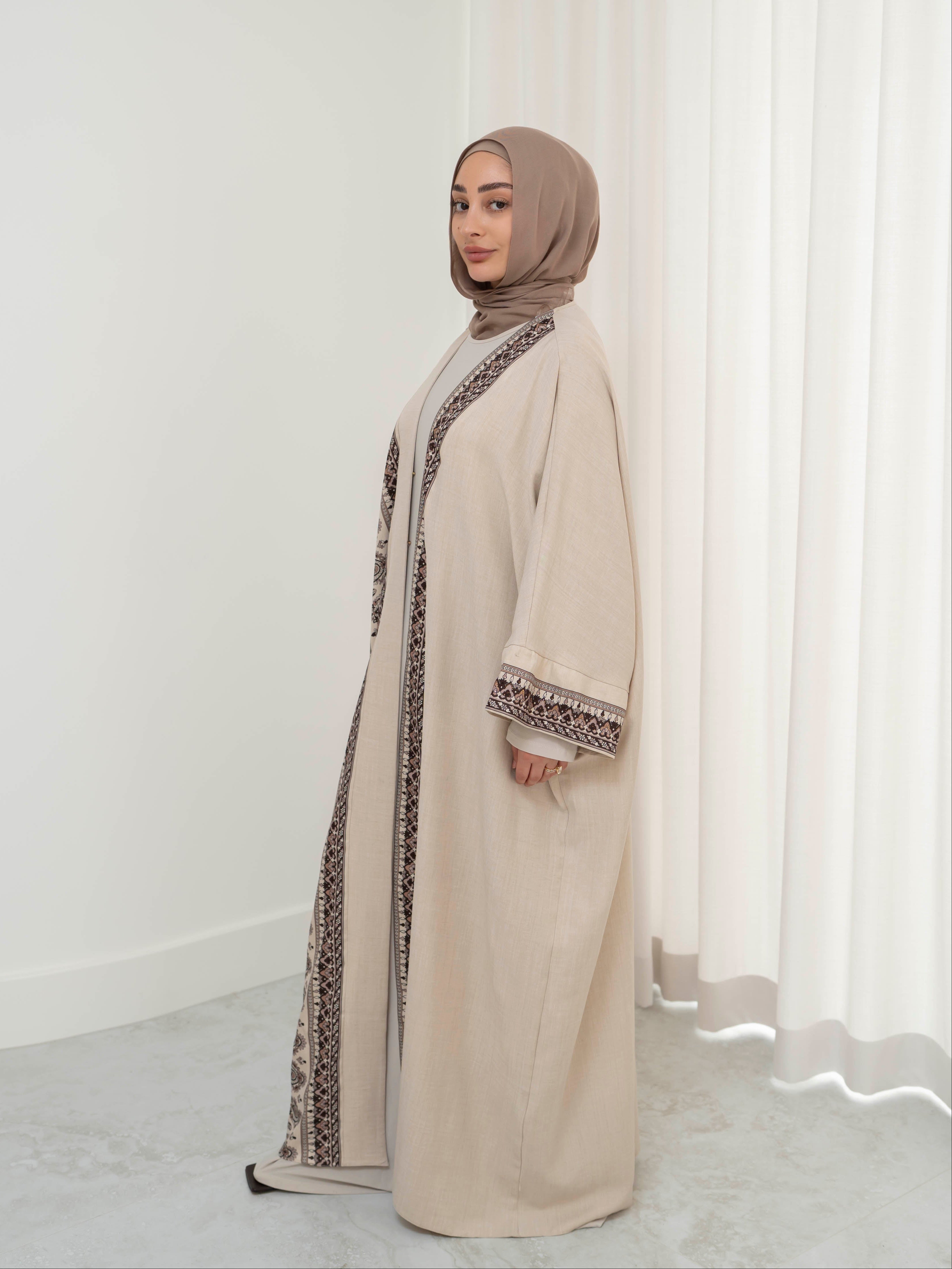 Model wearing the Safiya open abaya featuring a subtle patterned fabric and delicate embellishments, styled open for a modest and elegant look suitable for Ramadan and Eid occasions.