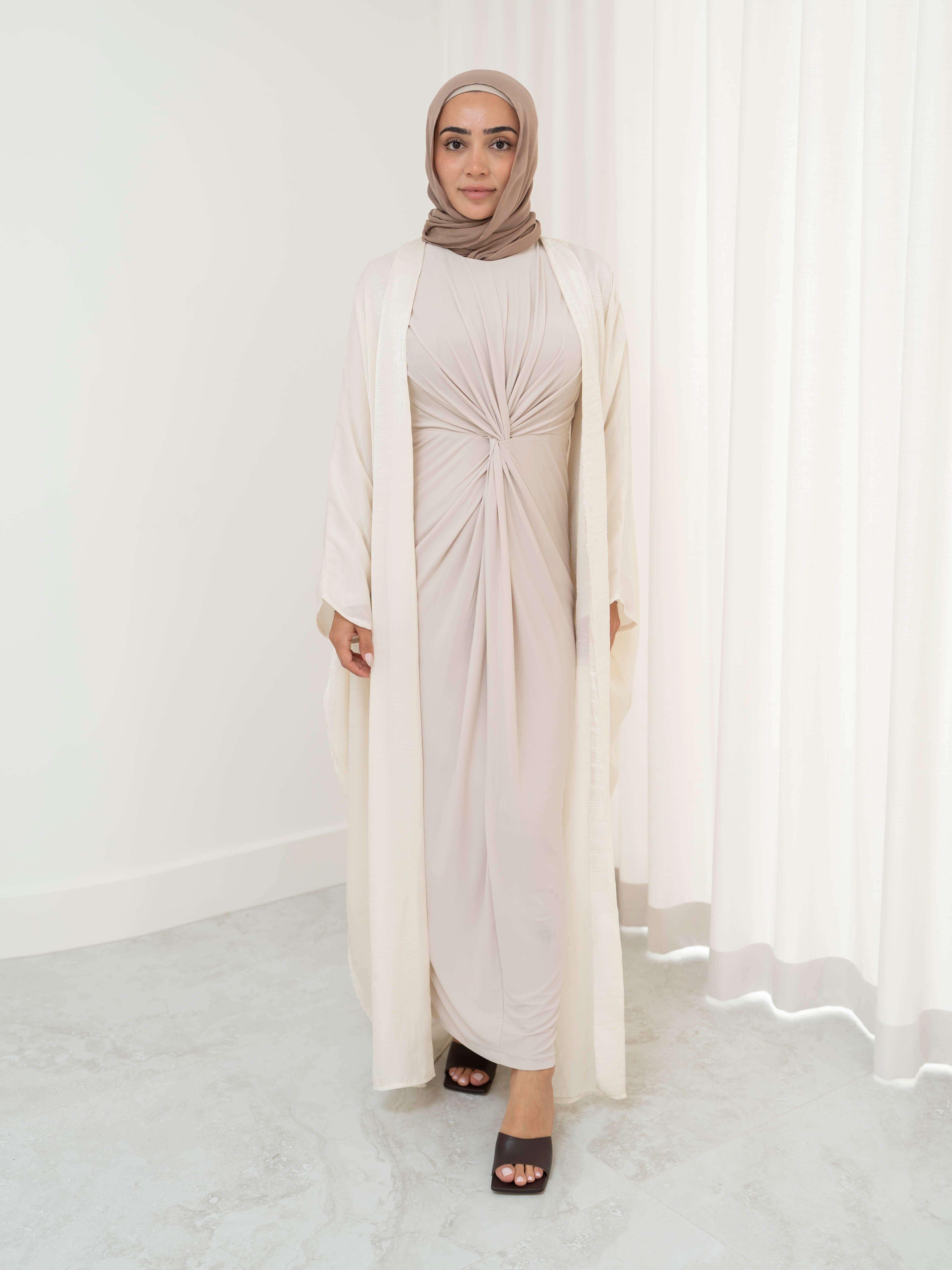 Model wearing the Layal two-piece set featuring a metallic shimmer open abaya layered over a coordinating dress., styled for a modest and elegant look suitable for Ramadan and Eid.