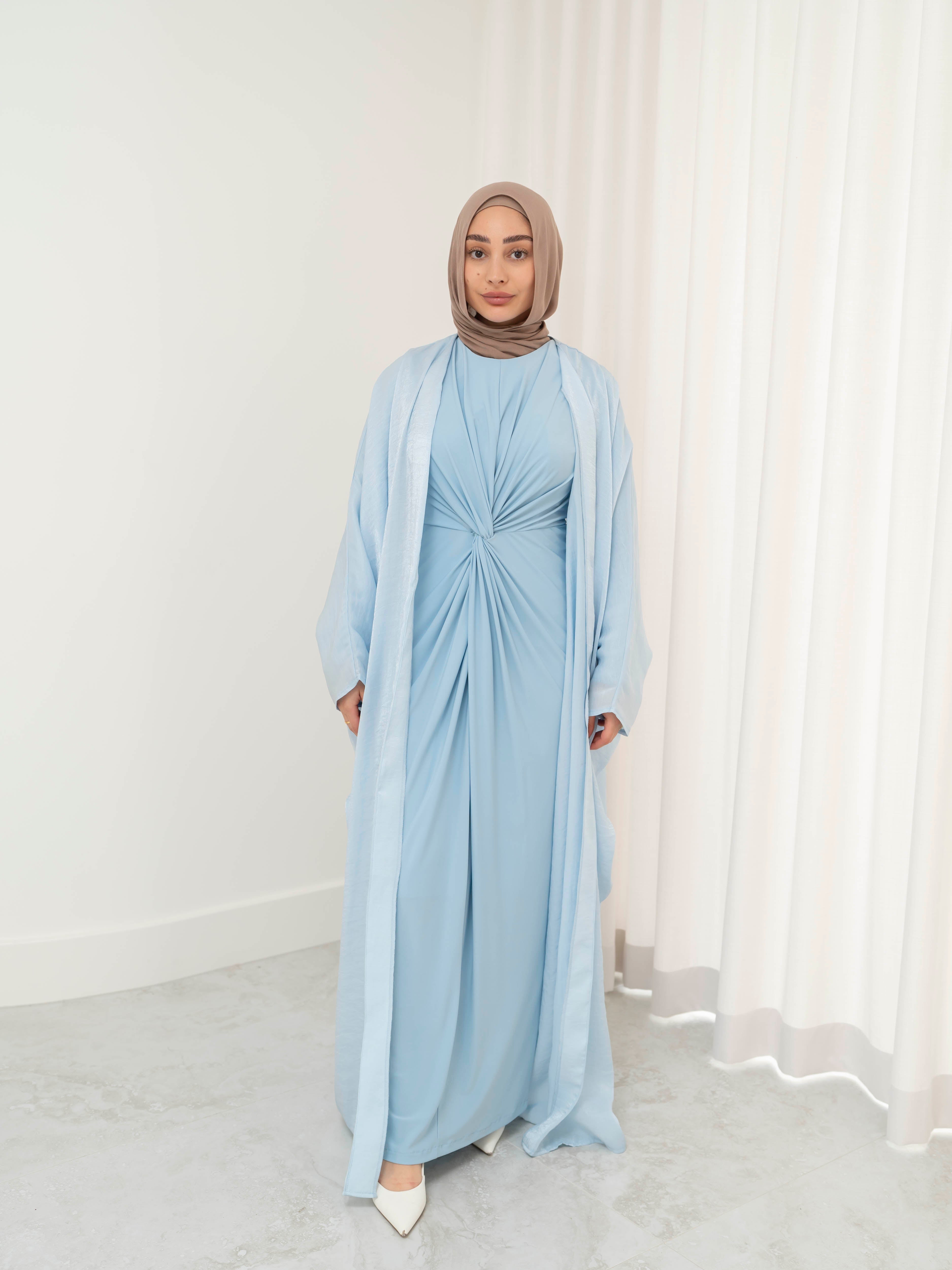 Model wearing the Layal two-piece set featuring a metallic shimmer open abaya layered over a coordinating dress., styled for a modest and elegant look suitable for Ramadan and Eid.