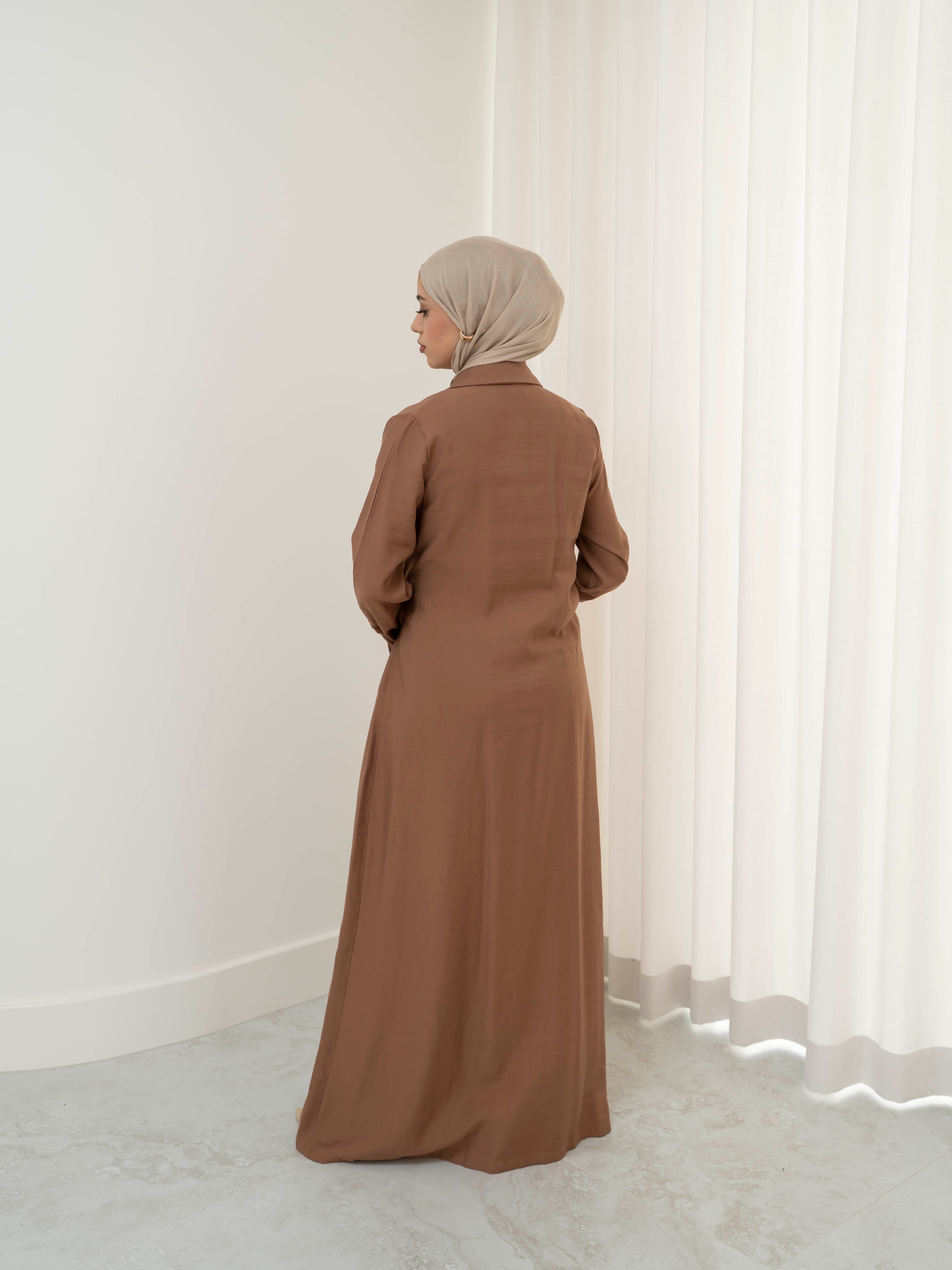 Alya Tie Dress, a full-length dress with adjustable waist tie, lapel neckline, and long sleeves with cuff finish. Lightweight fabric with soft drape, offering a modest, elegant silhouette for Eid, formal occasions, or refined everyday wear.