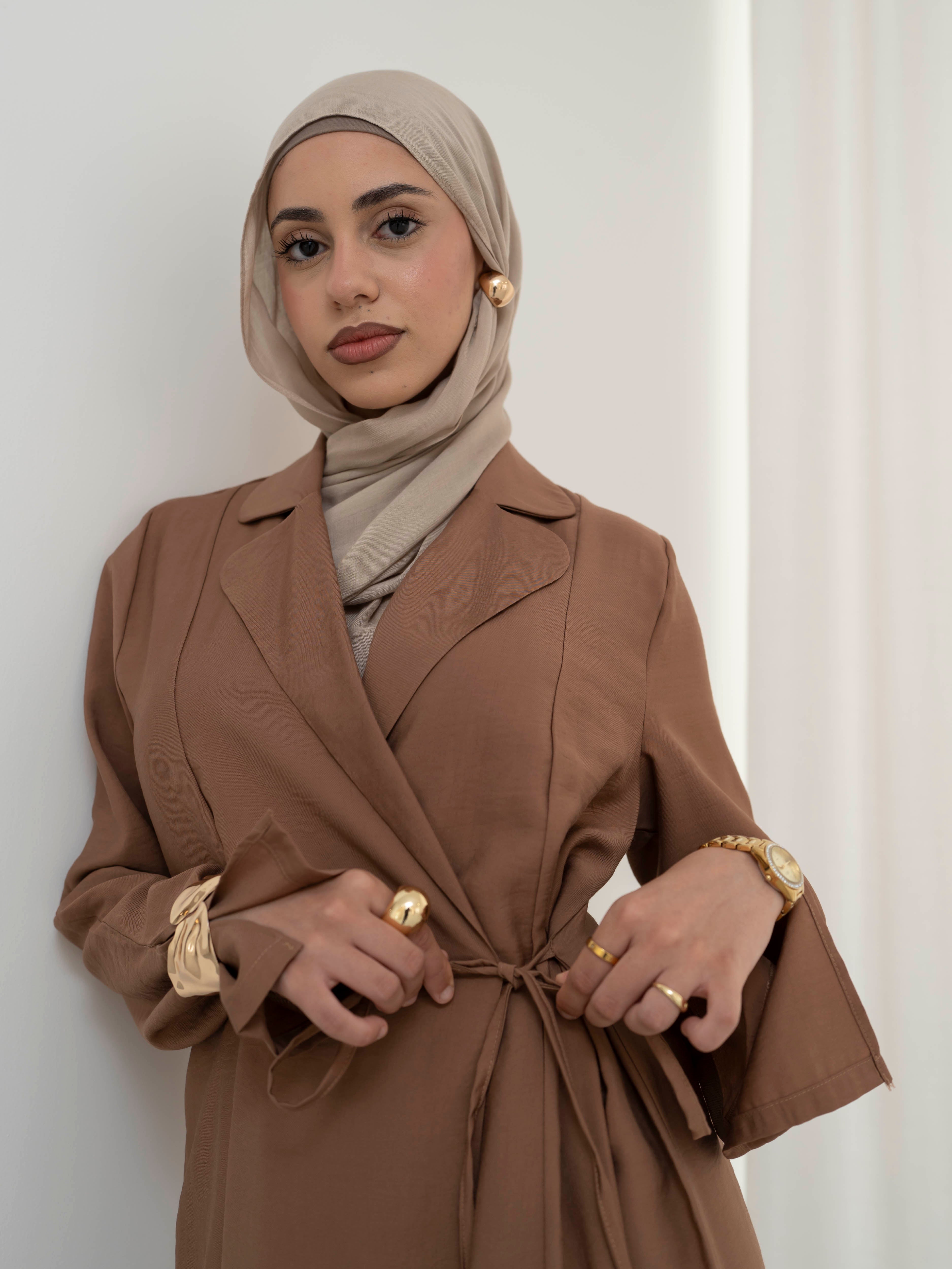 Alya Tie Dress, a full-length dress with adjustable waist tie, lapel neckline, and long sleeves with cuff finish. Lightweight fabric with soft drape, offering a modest, elegant silhouette for Eid, formal occasions, or refined everyday wear.