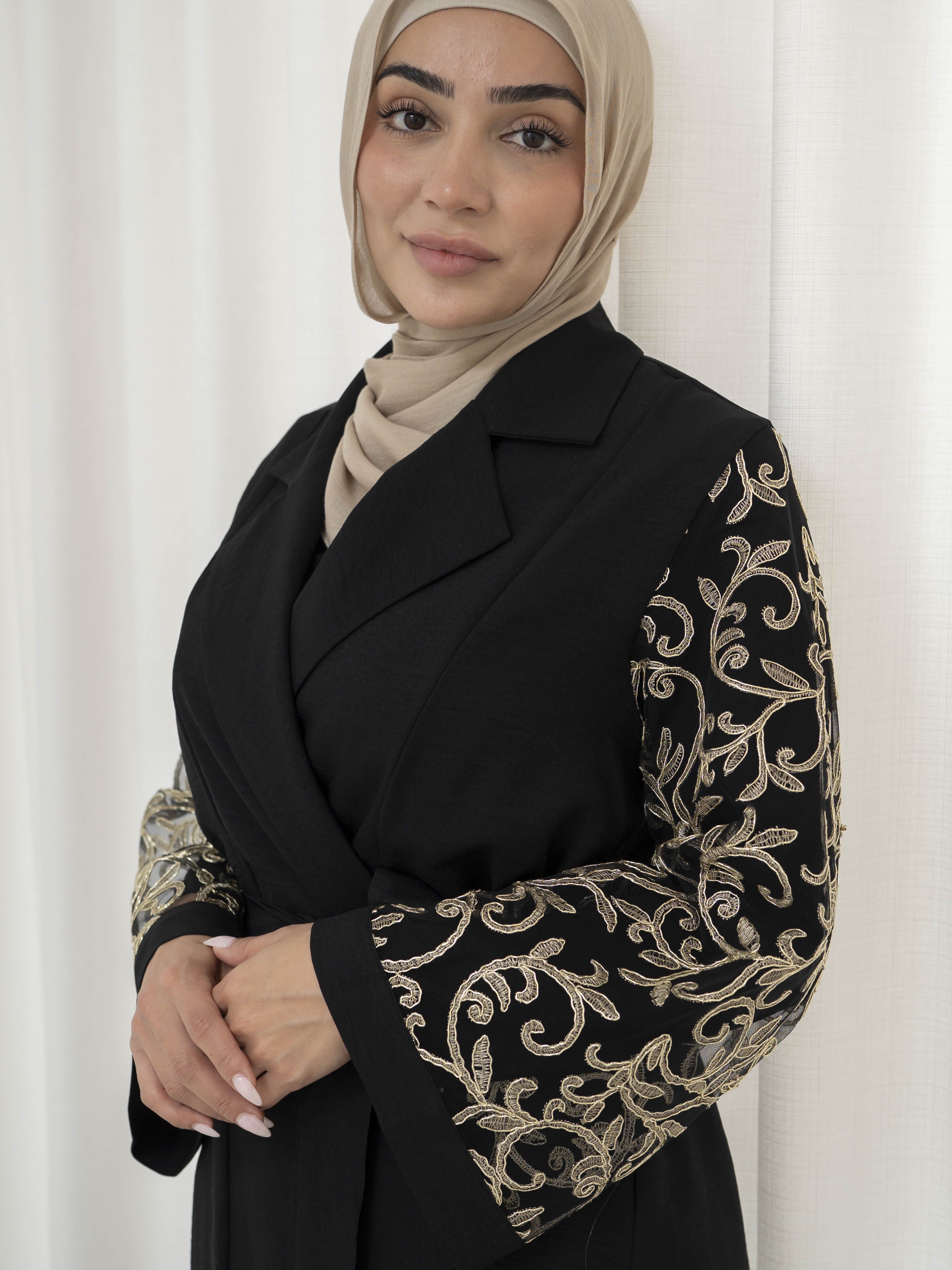 Amani Embroidered Set, a three-piece ensemble with a tailored jacket featuring sheer embroidered sleeves and tie belt, paired with a long-sleeve lycra top and flowing crepe pants. Designed for a structured, elegant, and modest silhouette.