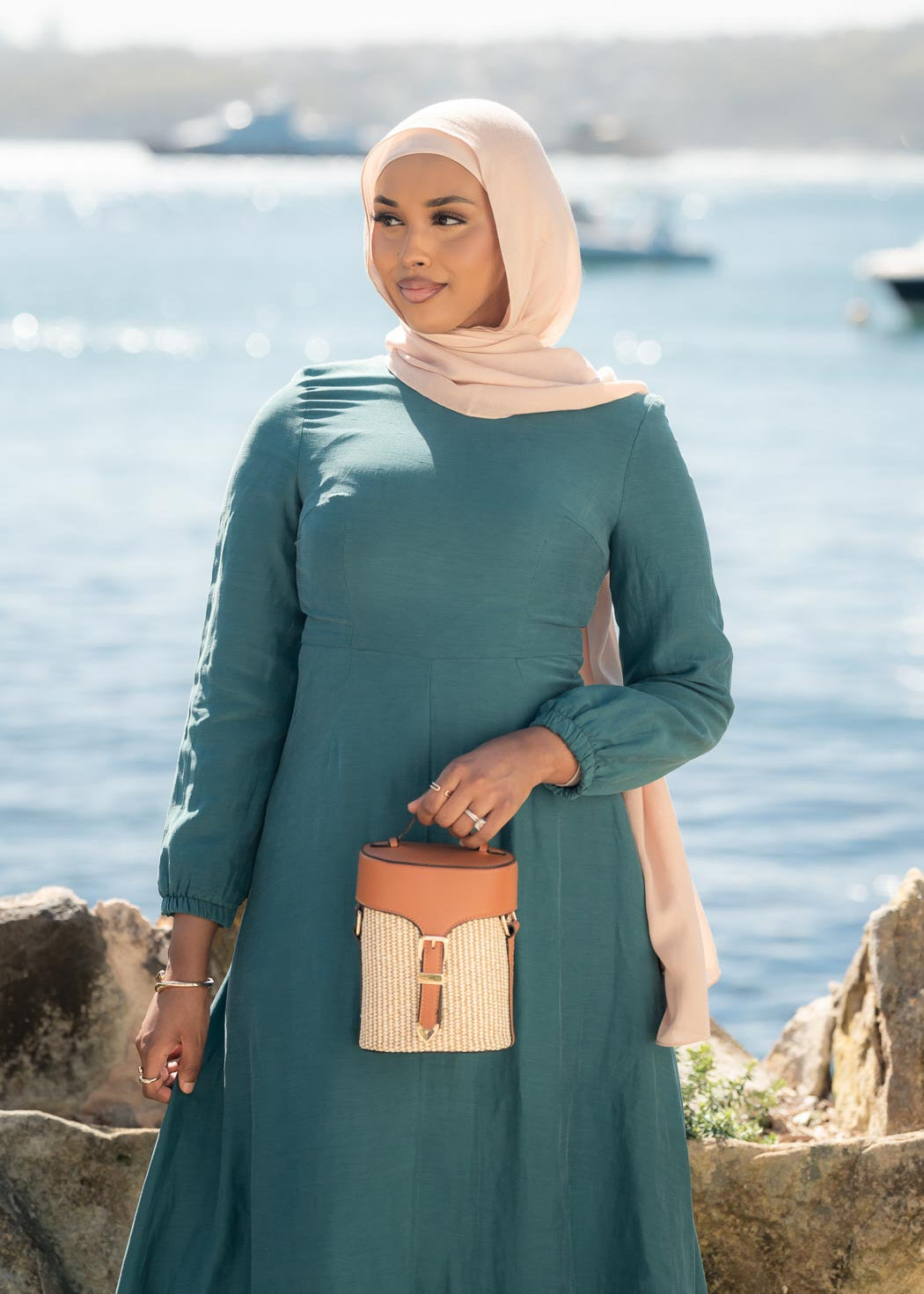 Amira Linen Dress in a soft linen-blend fabric with long sleeves and a fitted bodice featuring limited stretch. Designed with an empire waist that flows into a loose high-low skirt for an elegant, flattering silhouette suitable for special occasions.