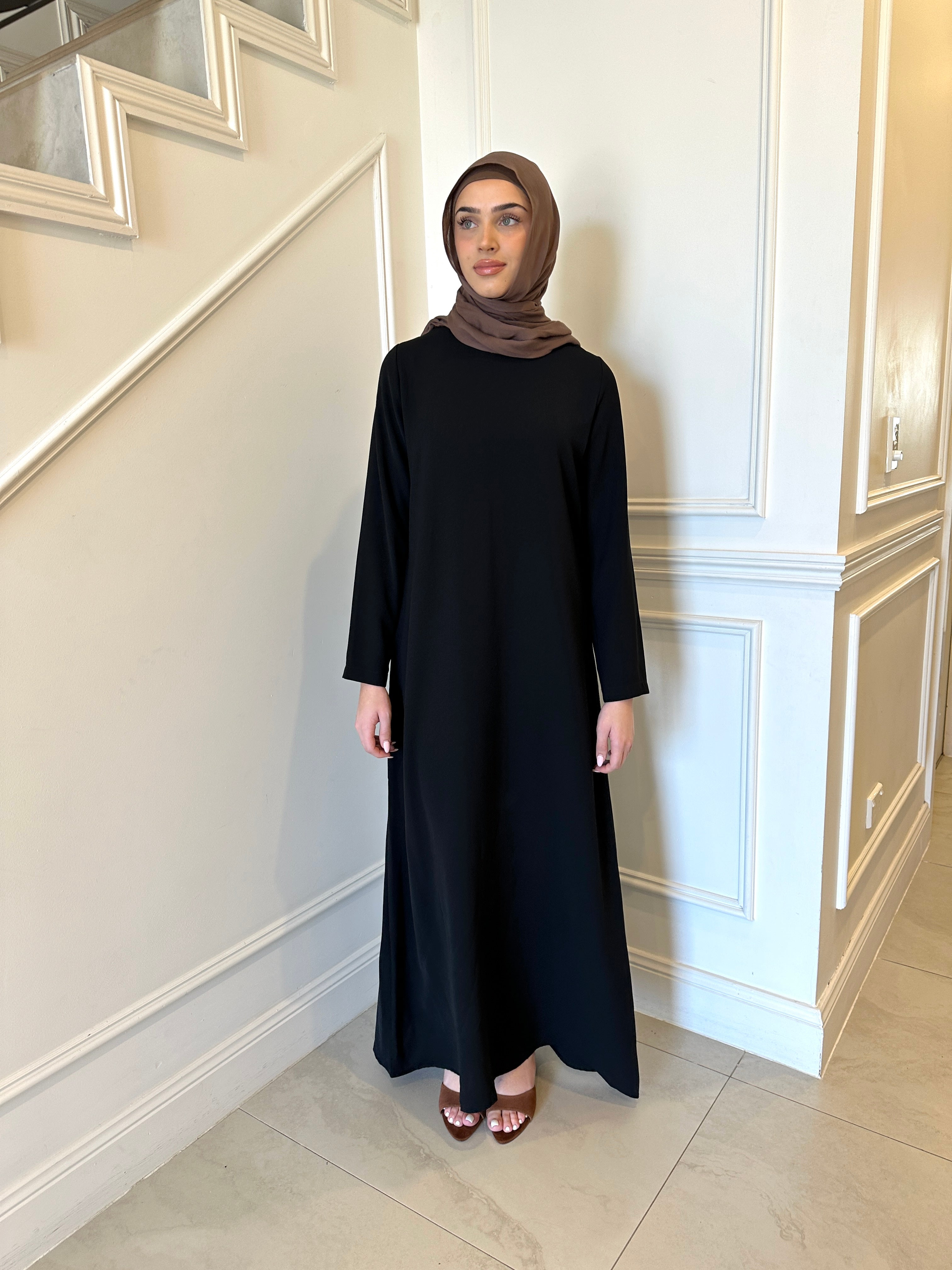 Basic Abaya in a classic straight-cut maxi silhouette with long sleeves and a round neckline. Minimalist design offers modest, polished elegance suitable for everyday wear or special occasions.