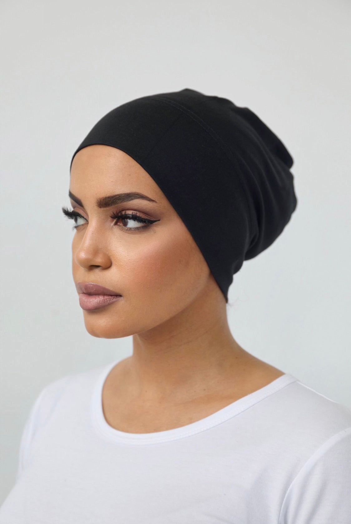 Bamboo under-scarf cap designed to cover hair beneath a hijab, made from soft, breathable natural bamboo fibers with cotton spandex stretch for comfort. Partially closed at the back with an elastic edge to comfortably accommodate hair.