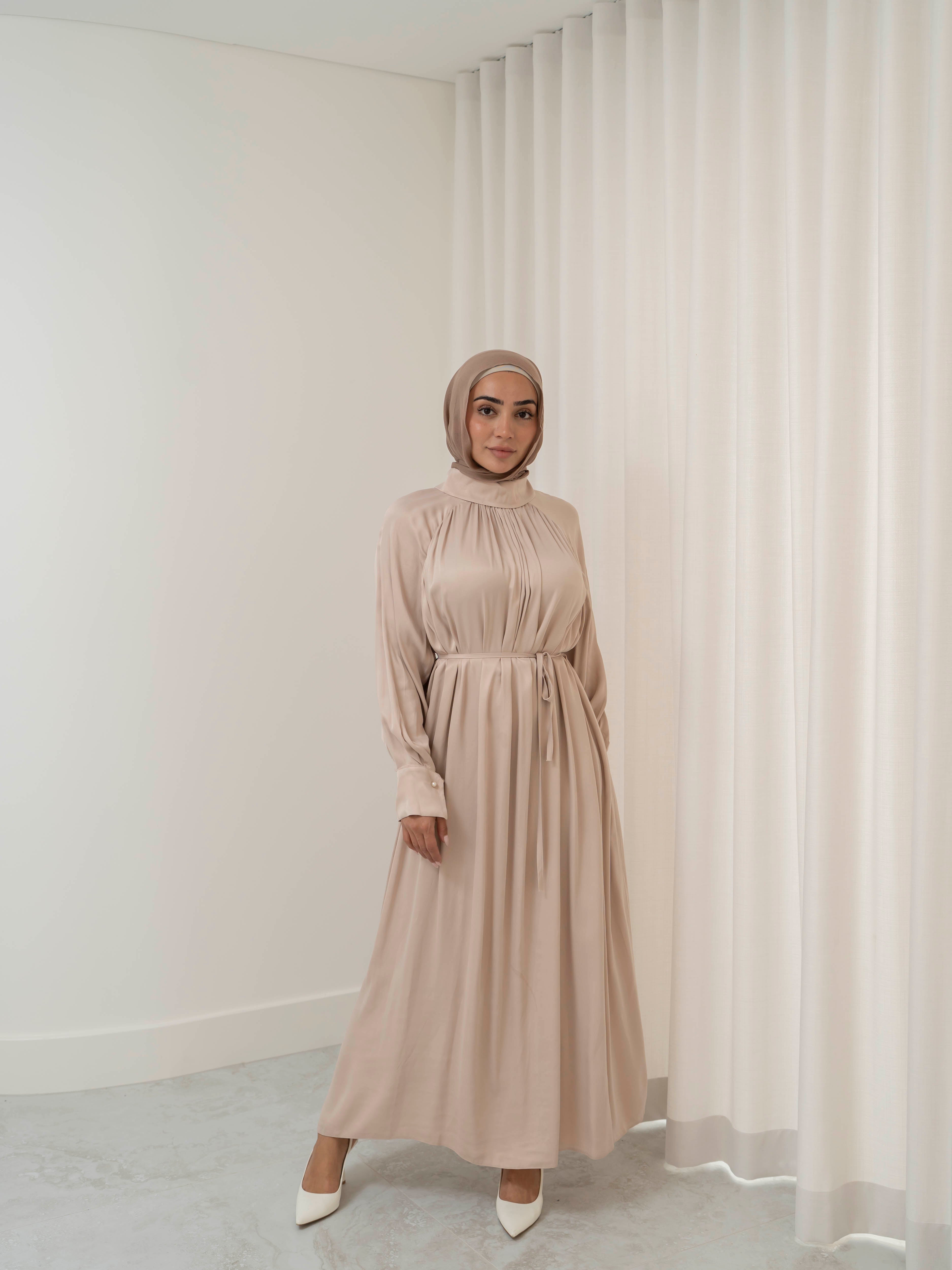 Celeste Tie Dress with a collared neckline, gathered bodice, and removable waist tie. Full-length with soft, fluid drape and subtle sheen, offering a graceful, elegant silhouette for Eid, special occasions, or evening wear.