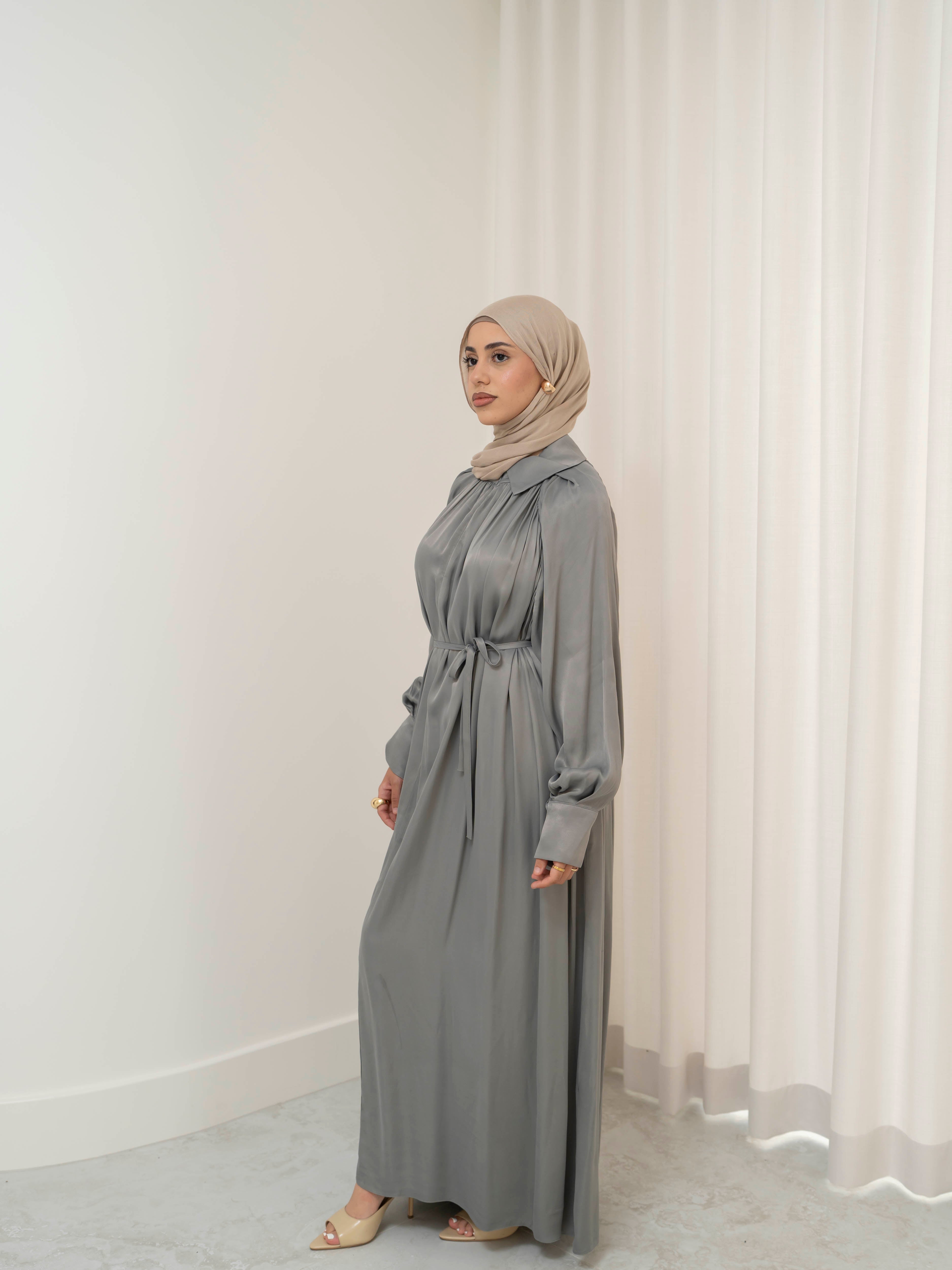 Celeste Tie Dress with a collared neckline, gathered bodice, and removable waist tie. Full-length with soft, fluid drape and subtle sheen, offering a graceful, elegant silhouette for Eid, special occasions, or evening wear.