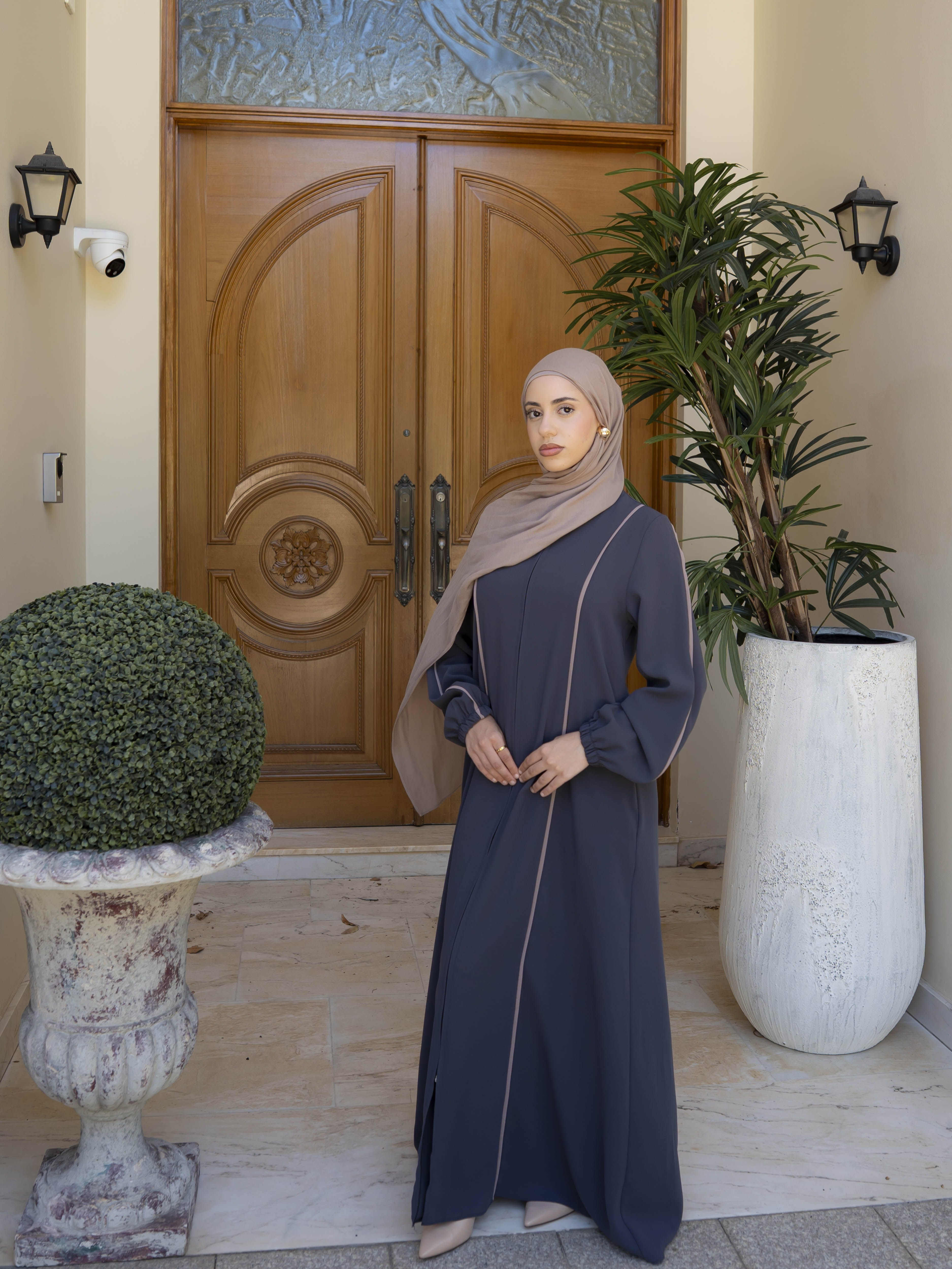 Elara Abaya with a longline, modest silhouette featuring a centre-front concealed zipper and elegant contrast piping. Flowing, structured design offers polished, tailored drape, ideal for everyday wear, gatherings, or Ramadan.