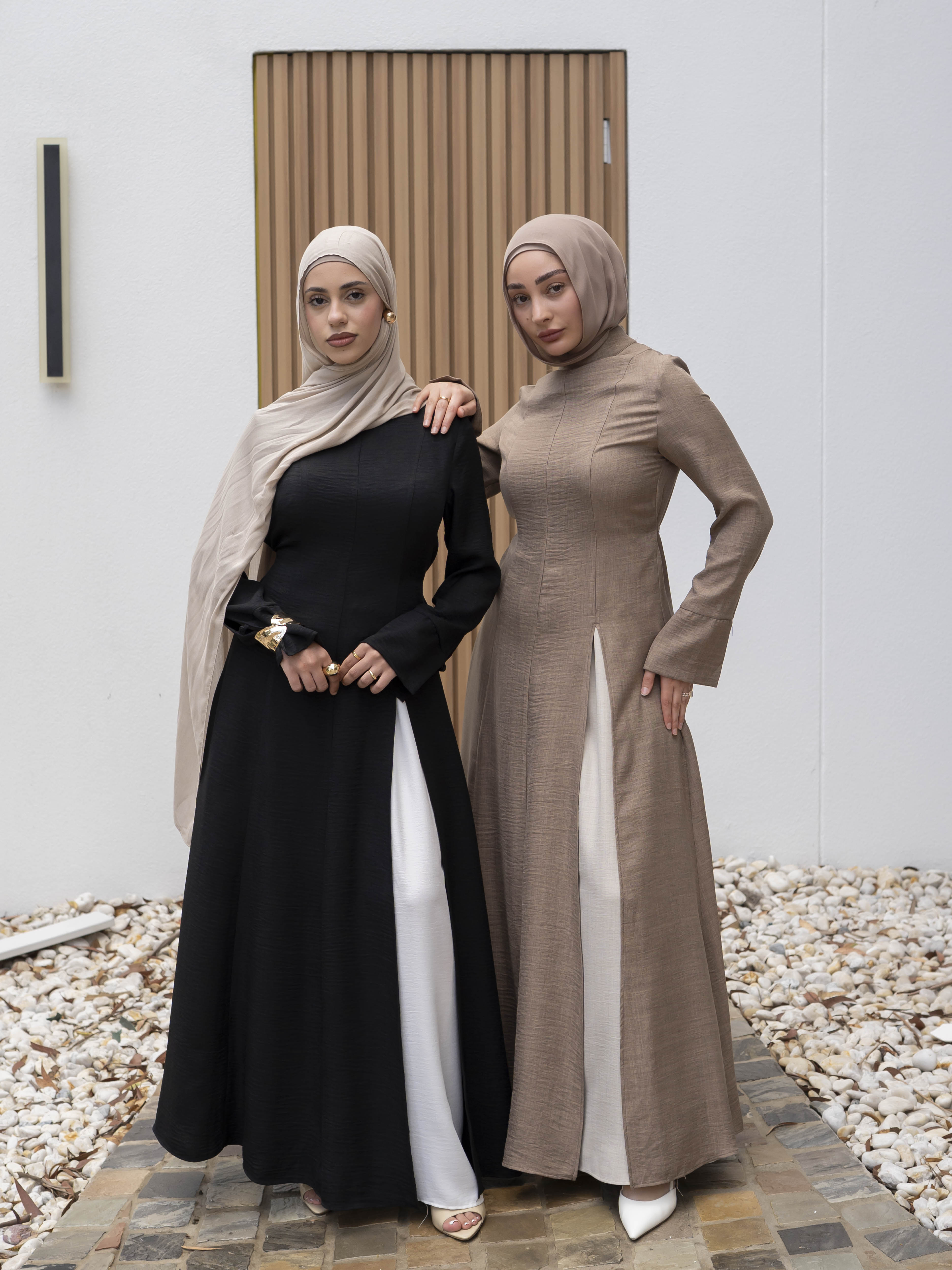 Isla Panelled Dress Set, a two-piece outfit with a tailored outer dress and contrasting inner skirt in a structured, full-length design. Features long sleeves with cuffs, an adjustable waist tie, and lightweight fabric with elegant drape, offering a modest and polished look for formal occasions or Eid.
