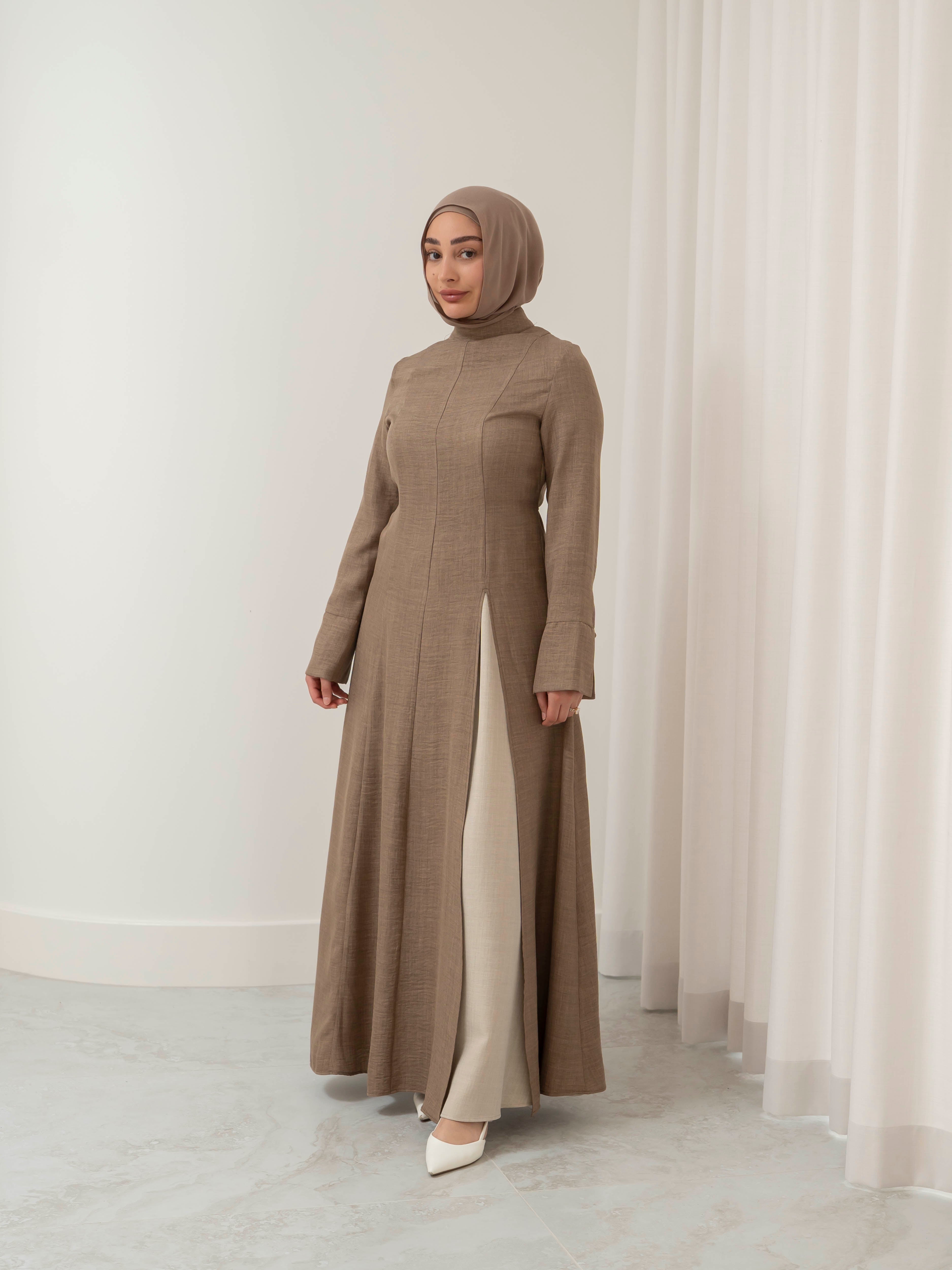 Isla Panelled Dress Set, a two-piece outfit with a tailored outer dress and contrasting inner skirt in a structured, full-length design. Features long sleeves with cuffs, an adjustable waist tie, and lightweight fabric with elegant drape, offering a modest and polished look for formal occasions or Eid.