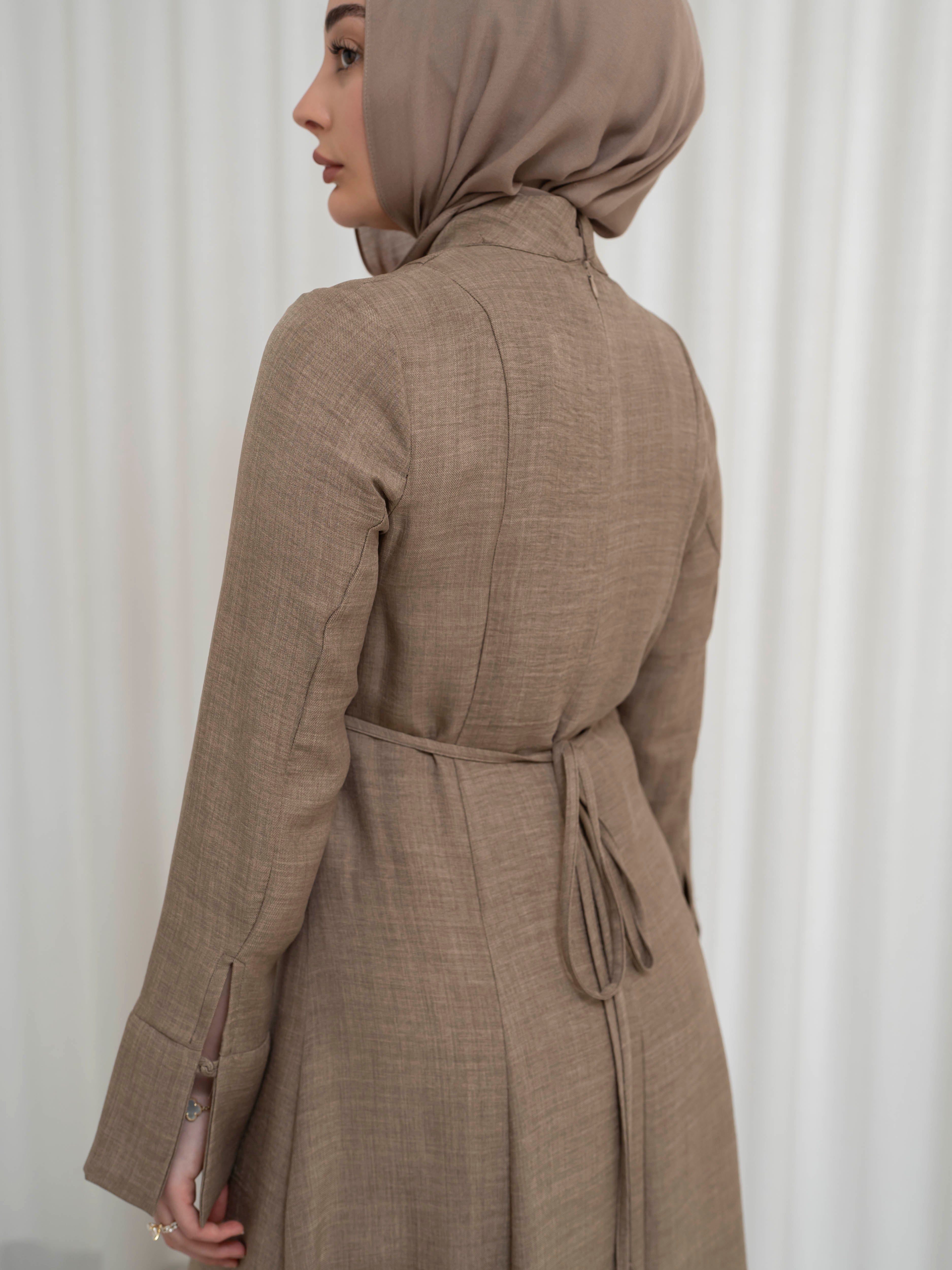 Isla Panelled Dress Set, a two-piece outfit with a tailored outer dress and contrasting inner skirt in a structured, full-length design. Features long sleeves with cuffs, an adjustable waist tie, and lightweight fabric with elegant drape, offering a modest and polished look for formal occasions or Eid.