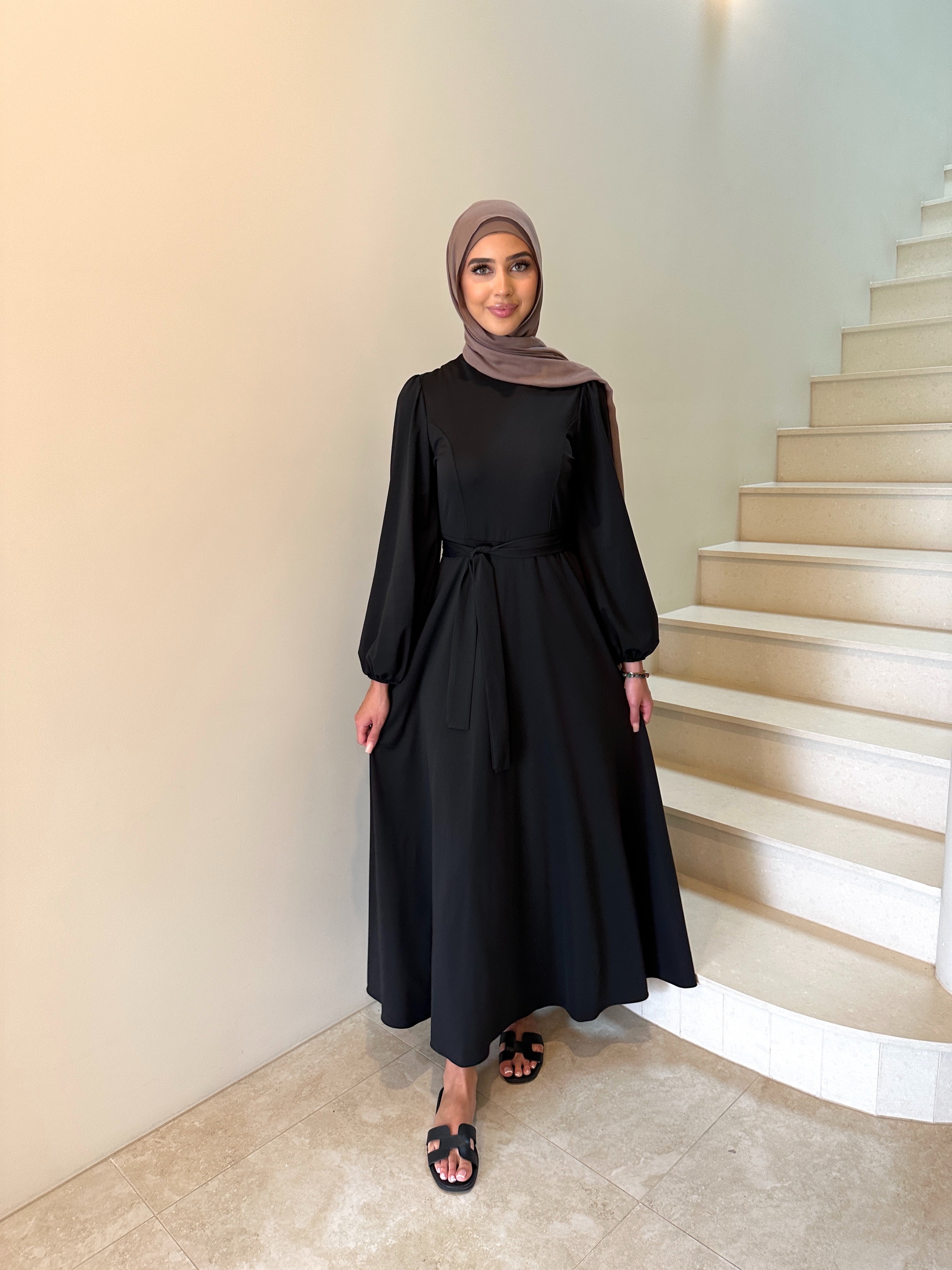 It has long sleeves and a fitted bodice with limited stretch, then drops from an empire cut waist to a loose high low skirt.