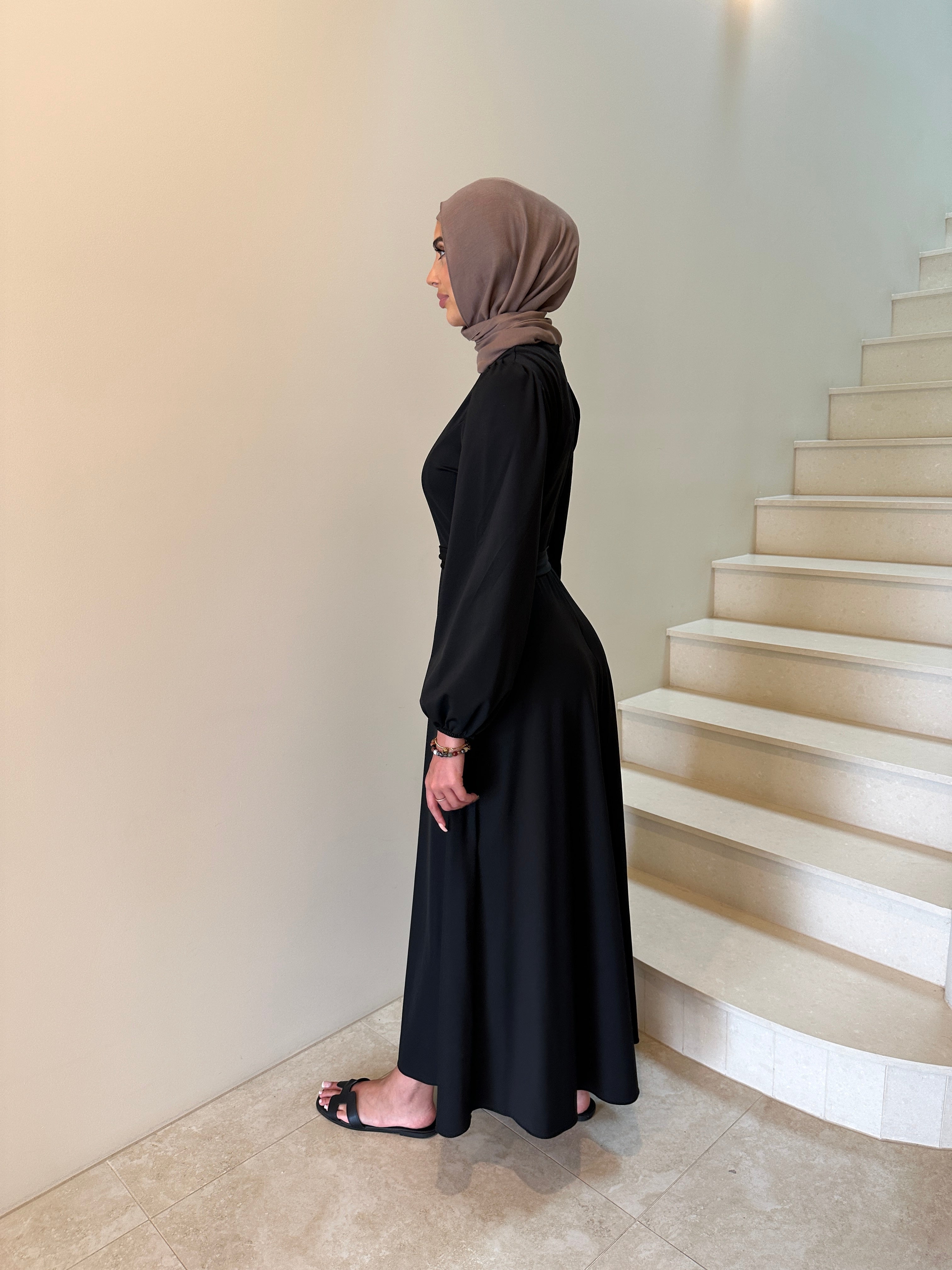 It has long sleeves and a fitted bodice with limited stretch, then drops from an empire cut waist to a loose high low skirt.