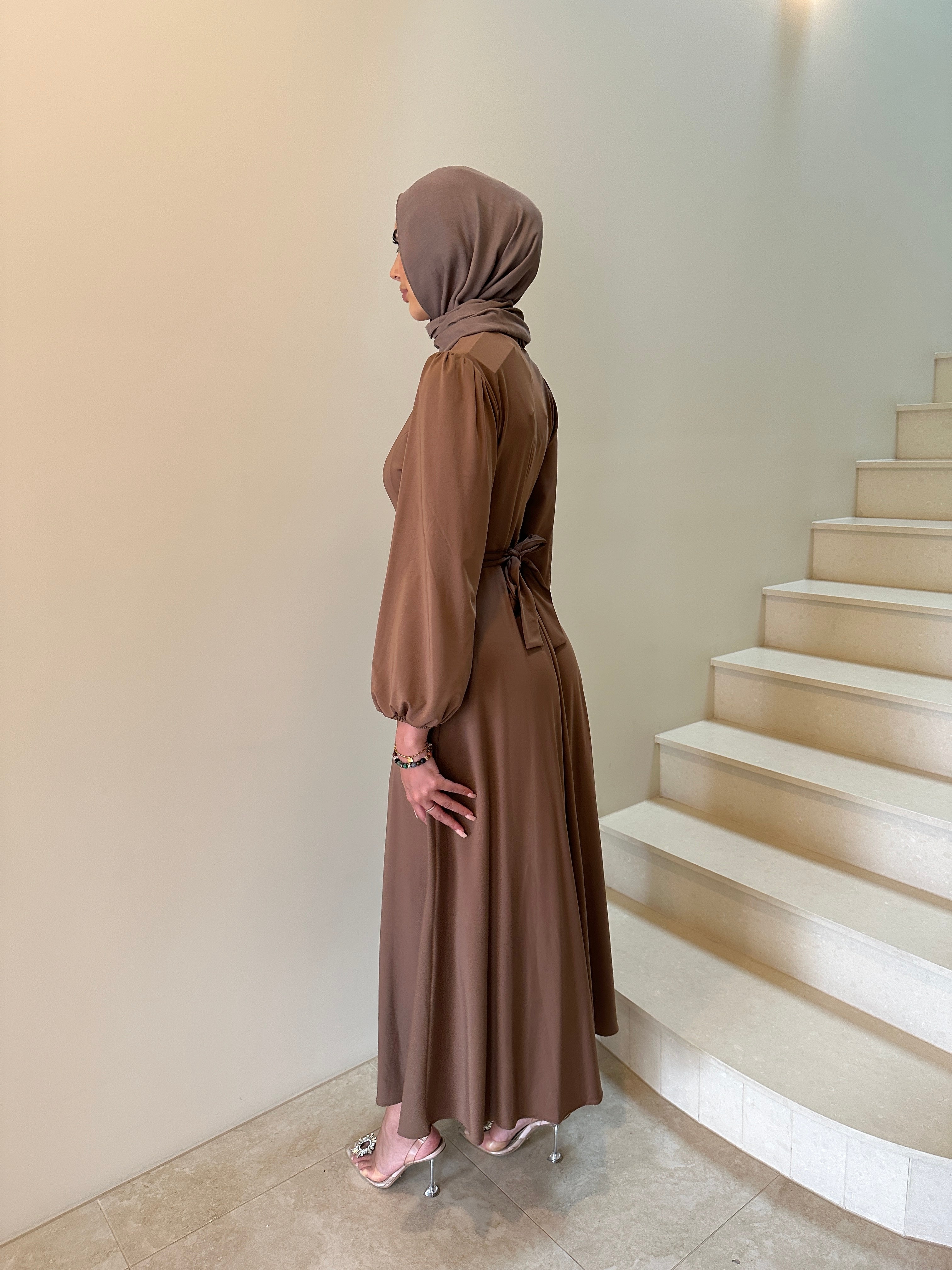 It has long sleeves and a fitted bodice with limited stretch, then drops from an empire cut waist to a loose high low skirt.