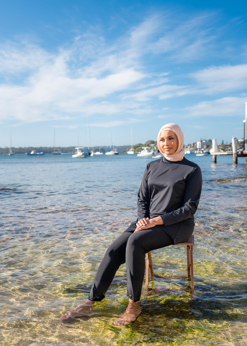 Model wearing the Marina modest swimwear set in black or mauve, featuring a long-sleeve top that falls above the knee and loose trousers with an elasticated waistband. Made from stretch scuba fabric (85% polyester, 15% elastane) for a comfortable fit.