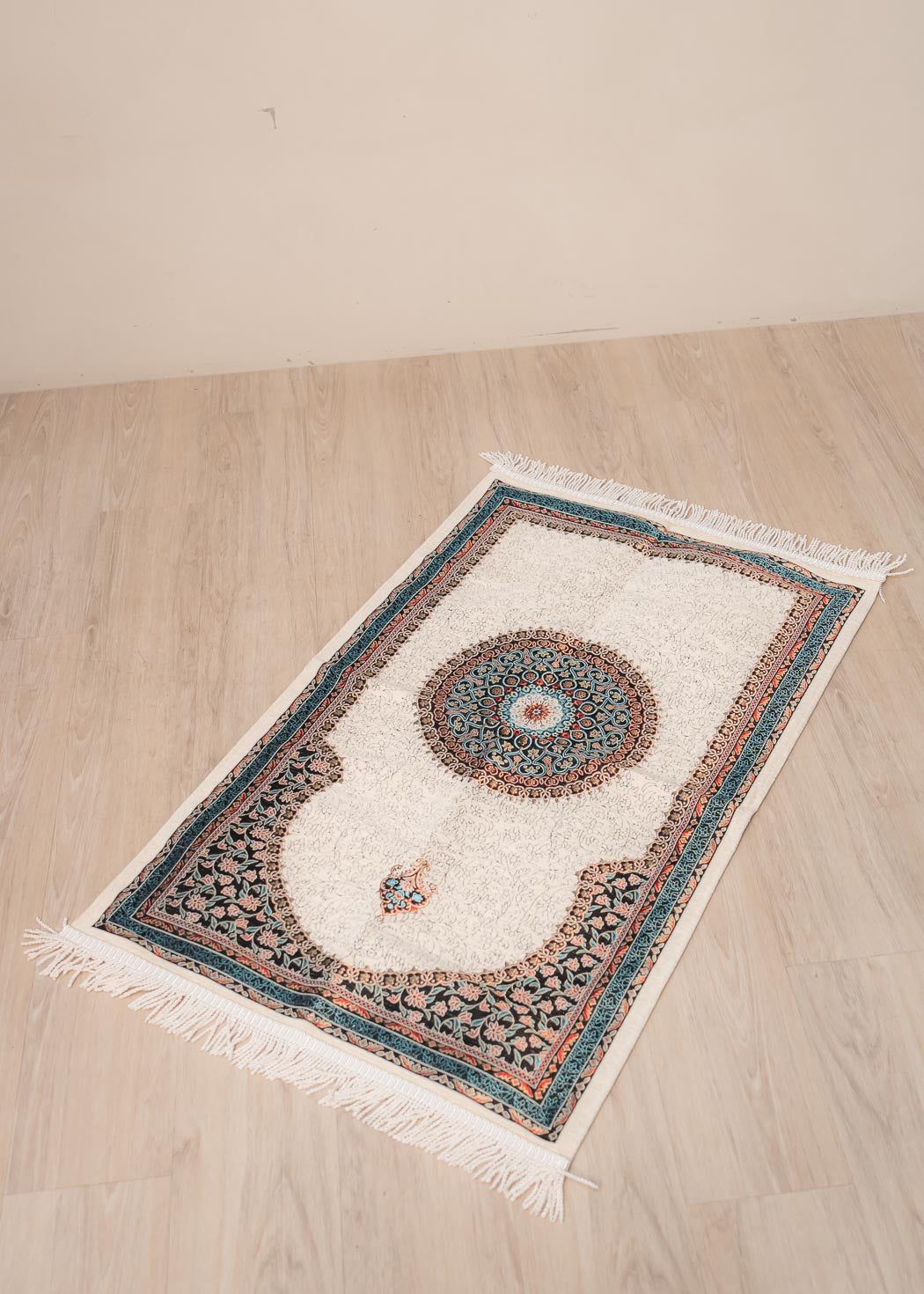 Soft cushioned prayer mat with braided fringe and traditional floral pattern 70cm x 120cm.