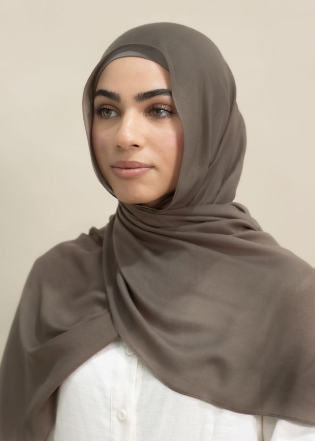Premium Modal Hijab in a warm, spice-inspired tone, measuring 190cm x 60cm with a single stitch edge. Lightweight and breathable with a soft, elegant drape, offering near opaque coverage for comfortable everyday or occasion wear. Hand wash cold. Styled with a moss cotton undercap.
