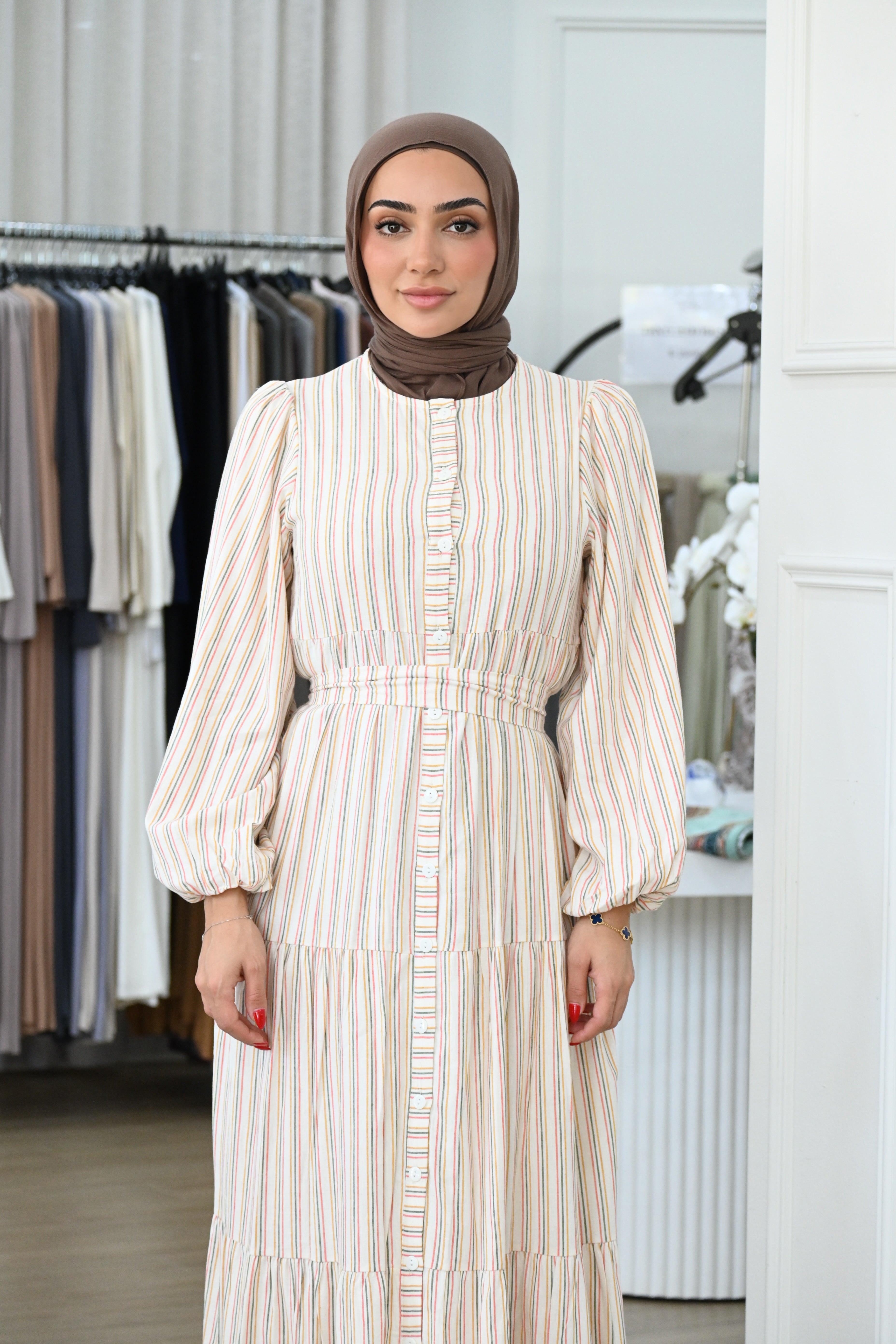 Designed with a button-down front, gathered waist, and tiered skirt, it flows beautifully with every step. Fully lined polyester fabric.