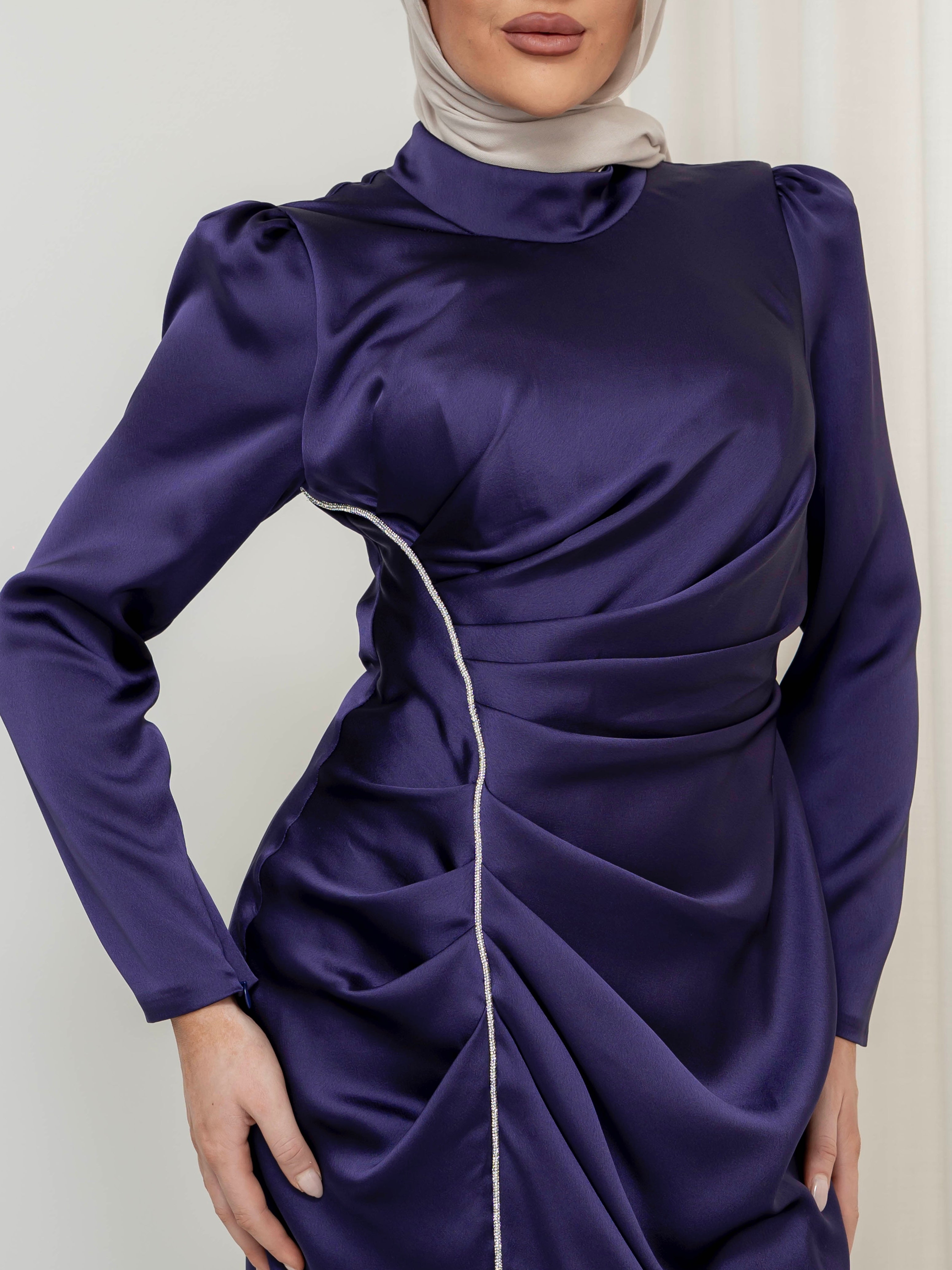 Elevate your formal look with the OLA FORMAL DRESS- INDIGO. Crafted from a shiny satin crepe fabric, this dress boasts elegant asymmetric gathers and a flattering silhouette that will make you stand out. Complete with long slim sleeves and a floor-skimming hem, this dress is perfect for any formal occasion.