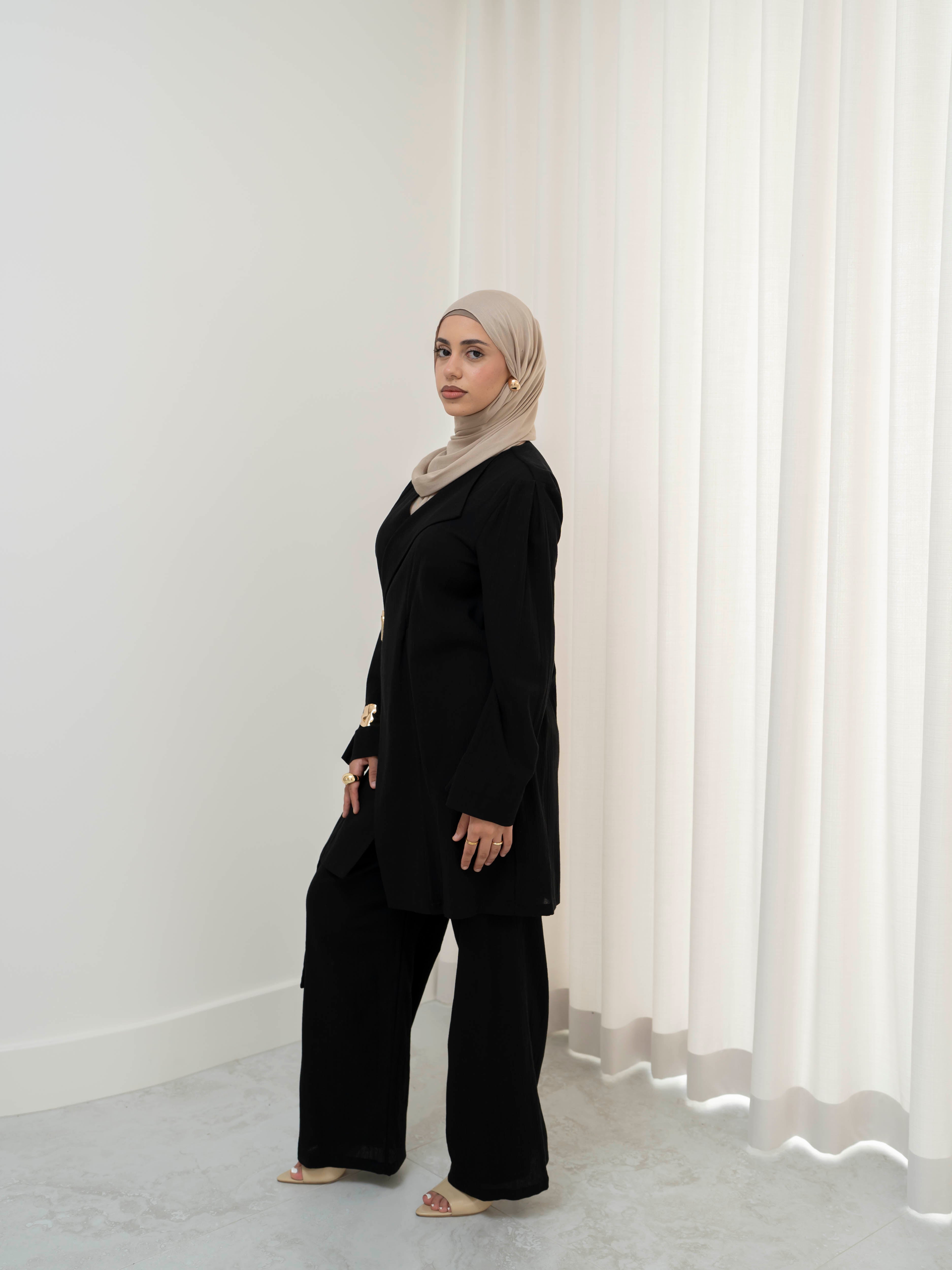 Raya Tailored Set, a two-piece outfit with a belted tailored jacket featuring structured lapels and matching wide-leg pants with elasticated waistband. Full-length, modest silhouette in lightweight fabric with refined drape, ideal for Eid, formal occasions, or elevated everyday wear.