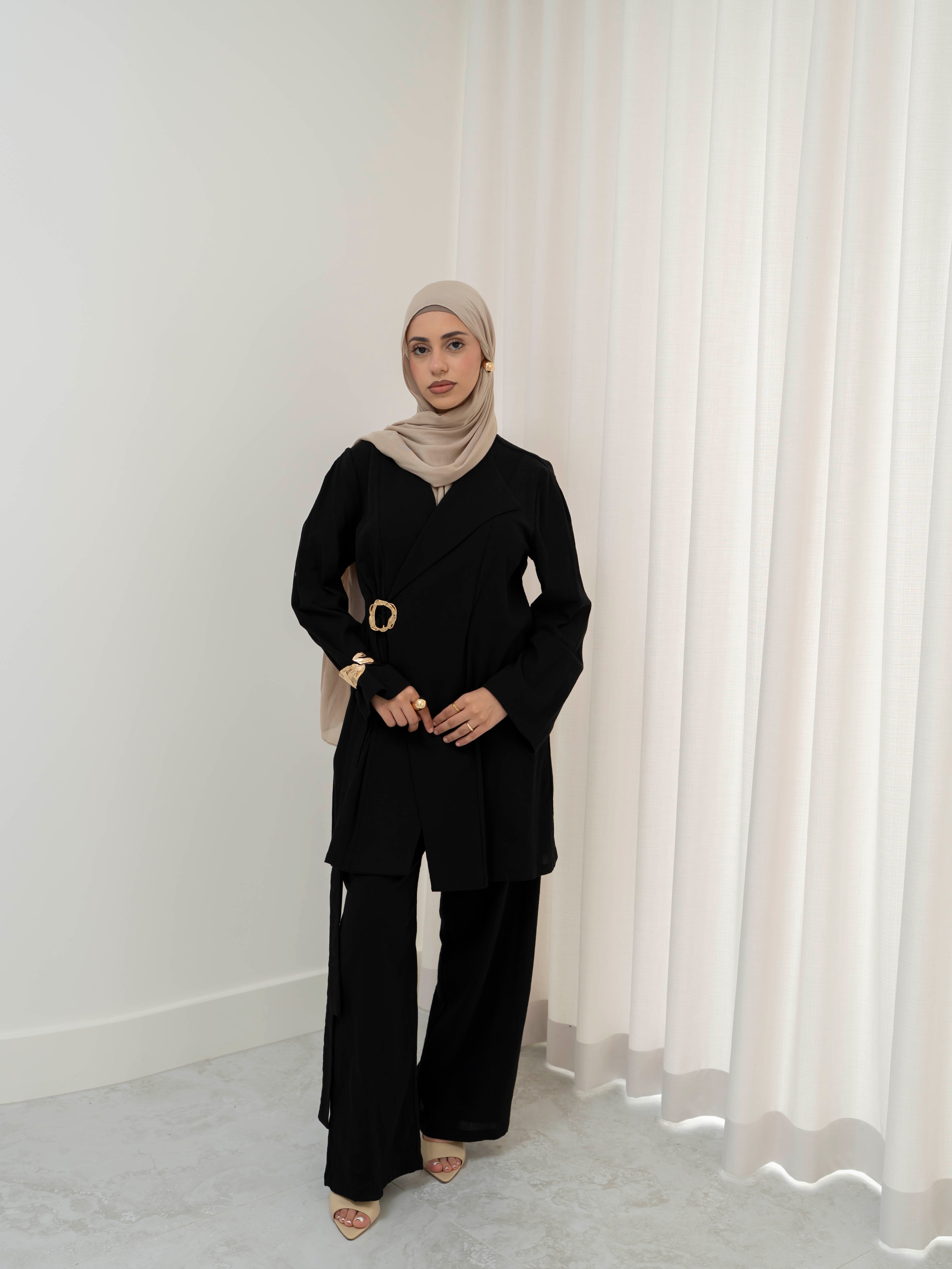 Raya Tailored Set, a two-piece outfit with a belted tailored jacket featuring structured lapels and matching wide-leg pants with elasticated waistband. Full-length, modest silhouette in lightweight fabric with refined drape, ideal for Eid, formal occasions, or elevated everyday wear.