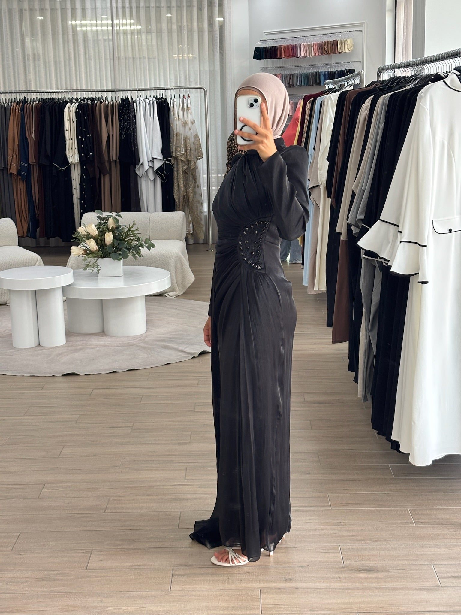 Reanne Formal Dress in glossy satin with a flattering ruched silhouette, high neckline, and long sleeves. Features embellished waist detailing, a draped floor-length panel, invisible back zip, and full lining — perfect for elegant formal occasions.