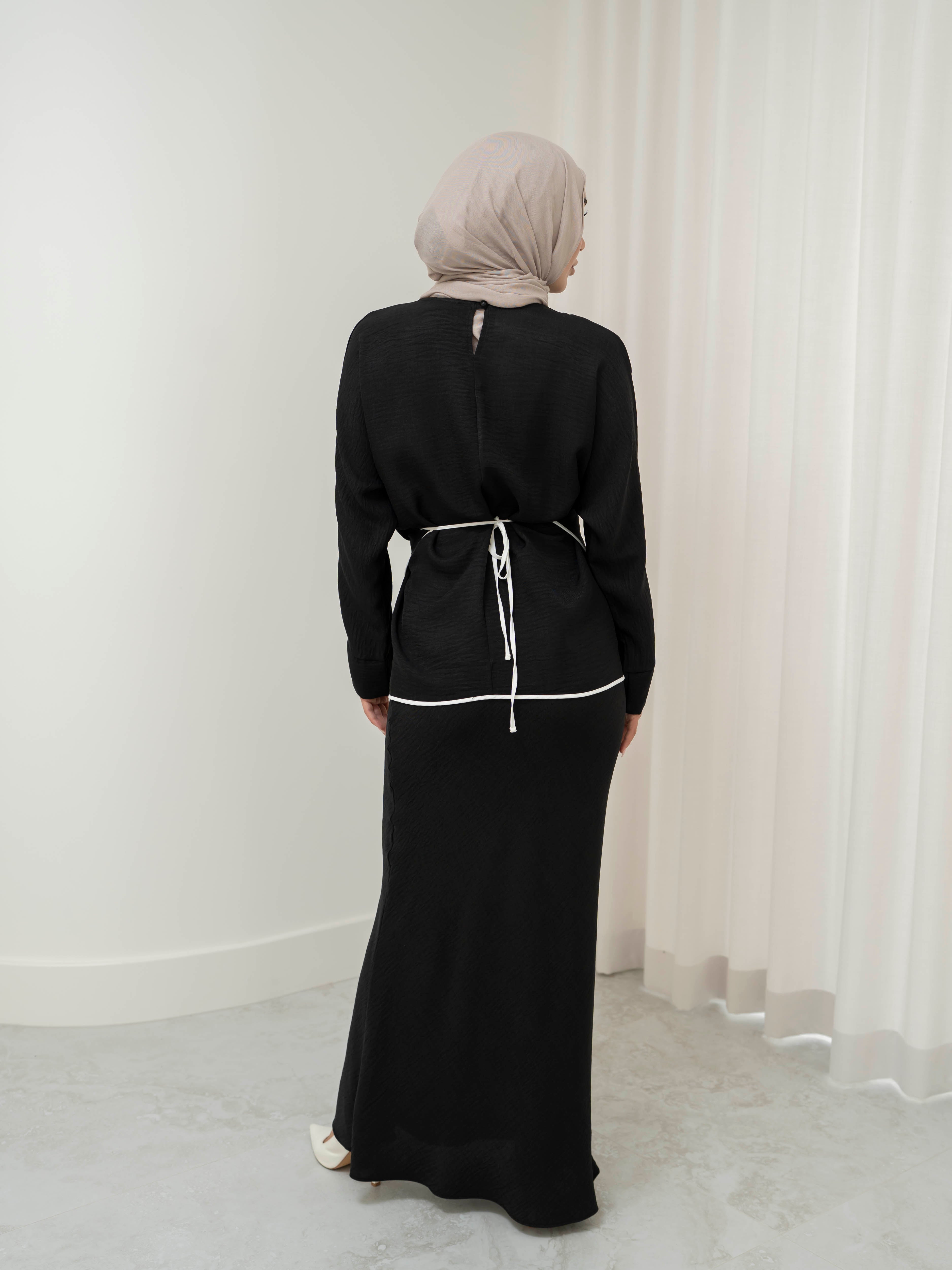 Sienna Wrap Set, a two-piece outfit with a wrap-style tie top featuring contrast piping and long sleeves, paired with a full-length flowing skirt. Lightweight fabric drapes elegantly for a modest, refined silhouette suitable for Eid, special occasions, or versatile everyday wear.