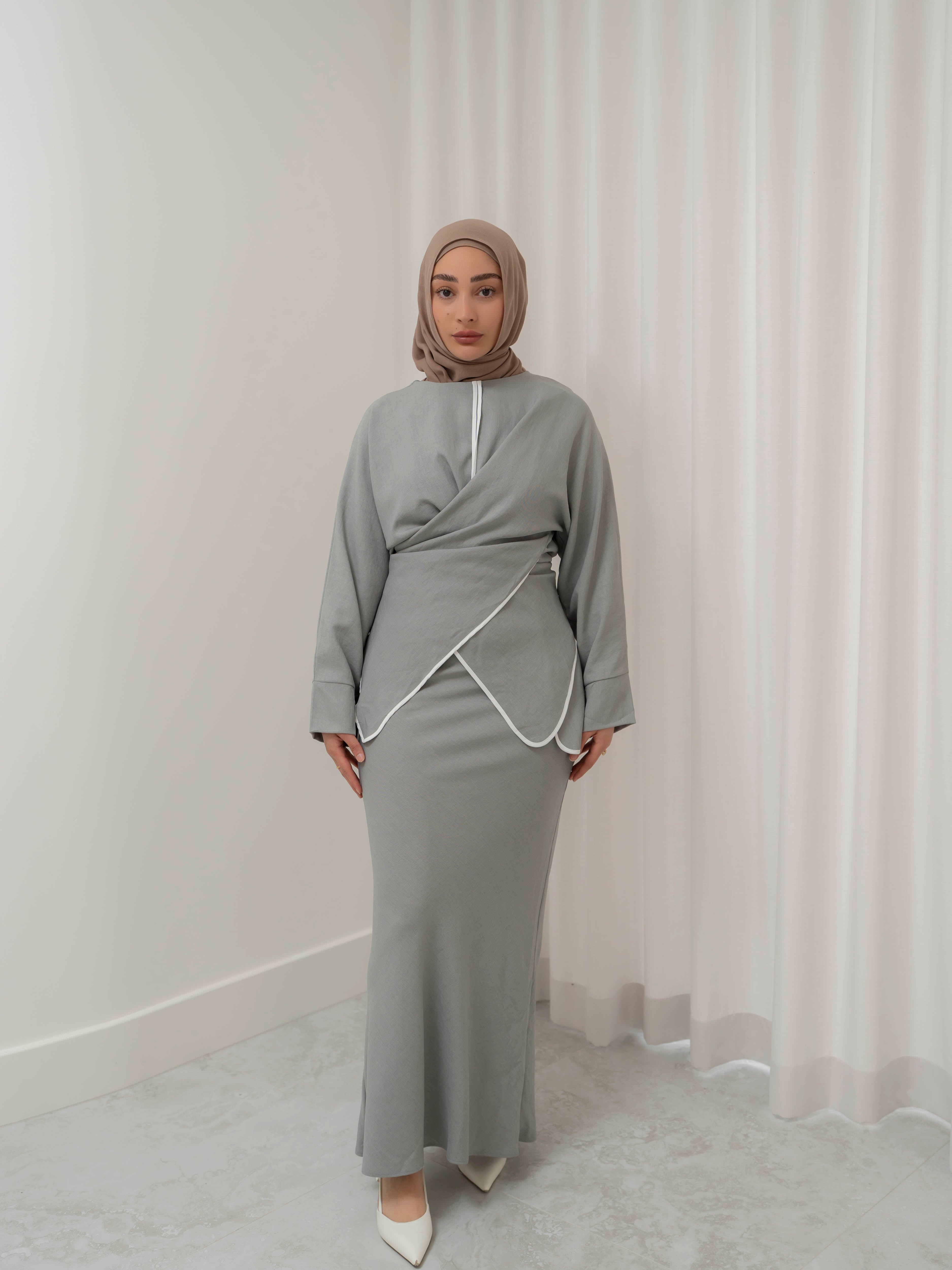 Sienna Wrap Set, a two-piece outfit with a wrap-style tie top featuring contrast piping and long sleeves, paired with a full-length flowing skirt. Lightweight fabric drapes elegantly for a modest, refined silhouette suitable for Eid, special occasions, or versatile everyday wear.
