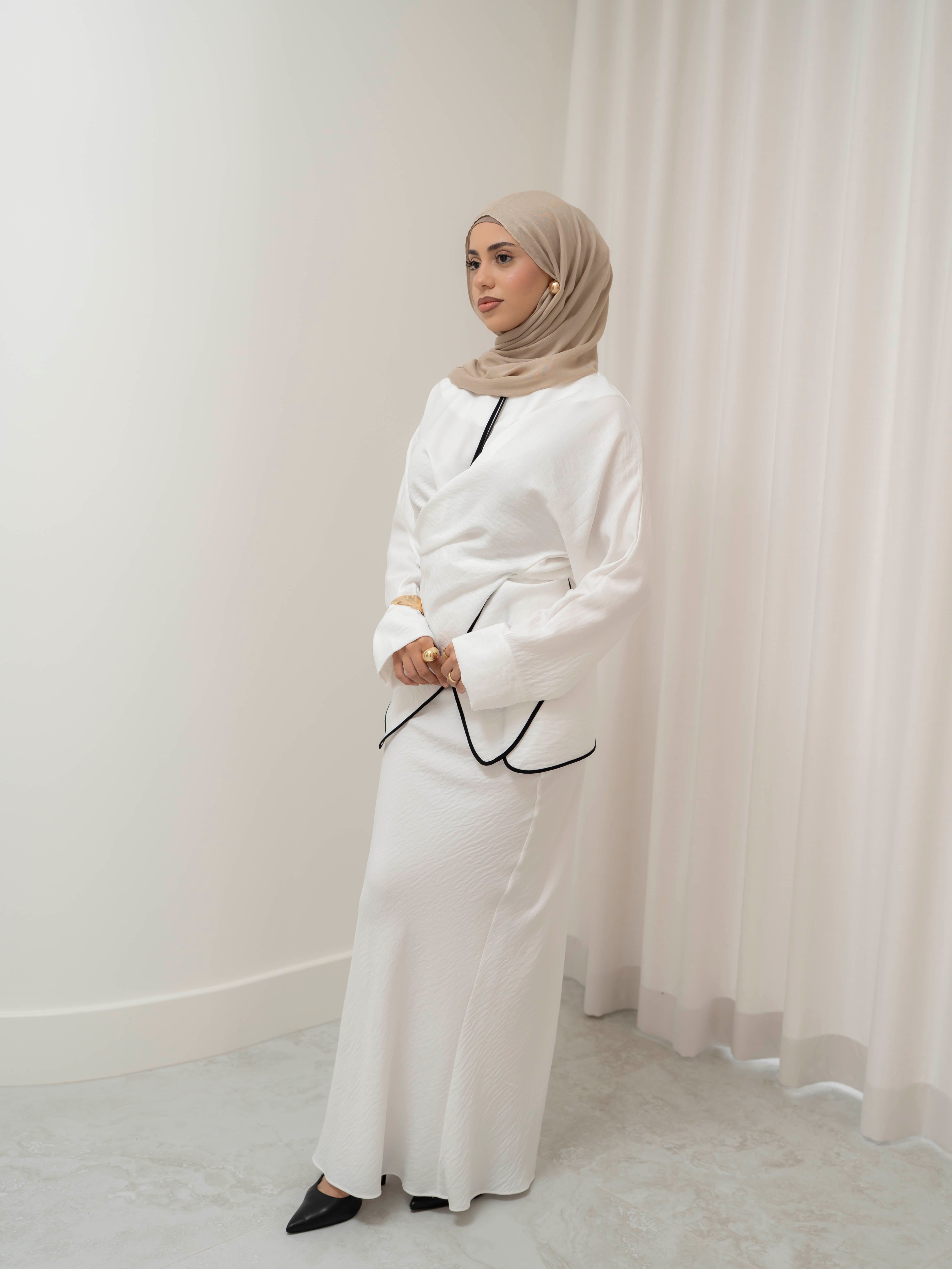 Sienna Wrap Set, a two-piece outfit with a wrap-style tie top featuring contrast piping and long sleeves, paired with a full-length flowing skirt. Lightweight fabric drapes elegantly for a modest, refined silhouette suitable for Eid, special occasions, or versatile everyday wear.