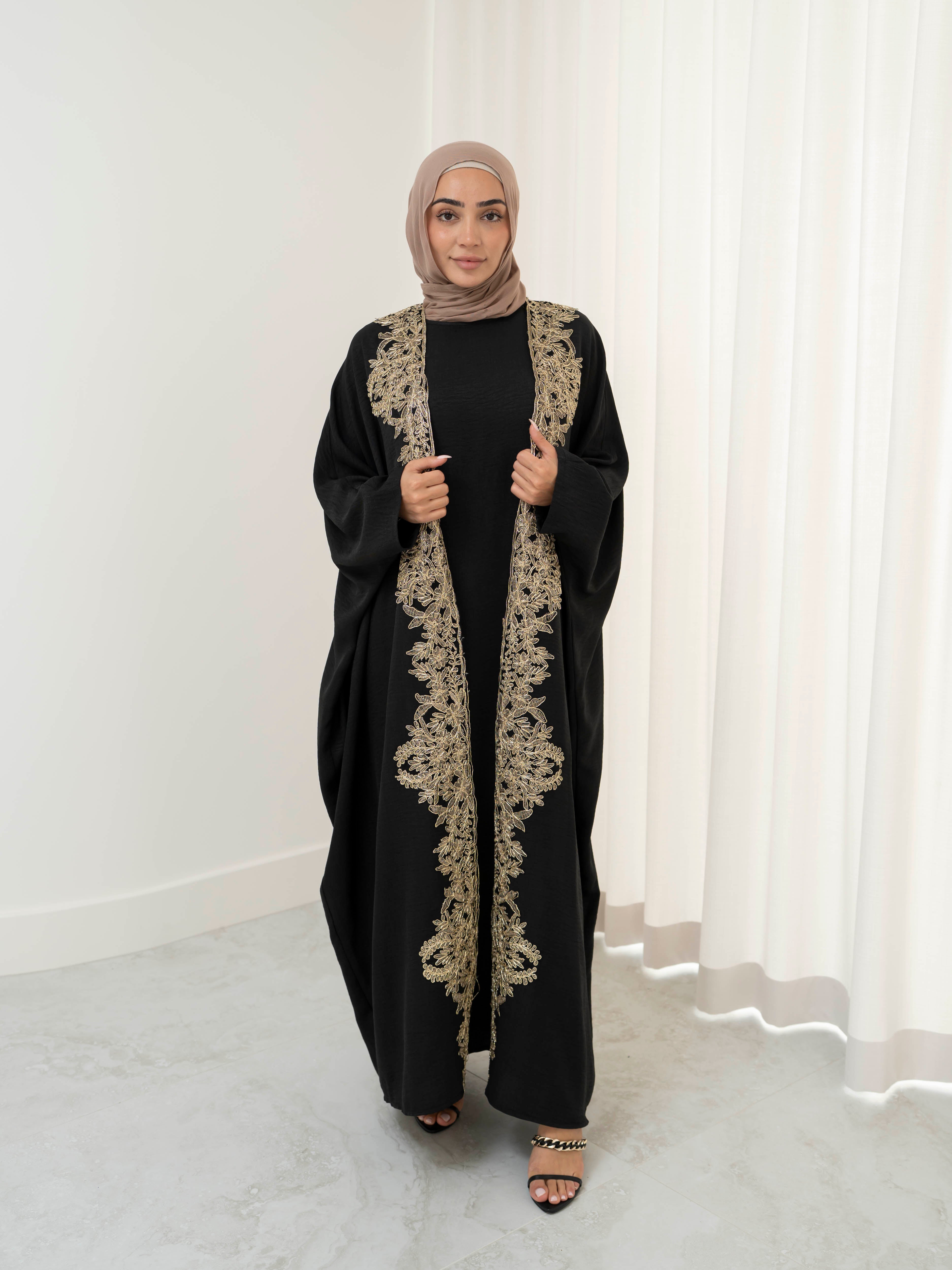 Sultanah Abaya with flowing silhouette and intricate gold embroidery, designed for elegant, modest formal wear. Features delicate gold detailing for a refined, regal finish and includes a sleeveless inner dress for comfortable layering. Perfect for Eid, special occasions, and formal gatherings.