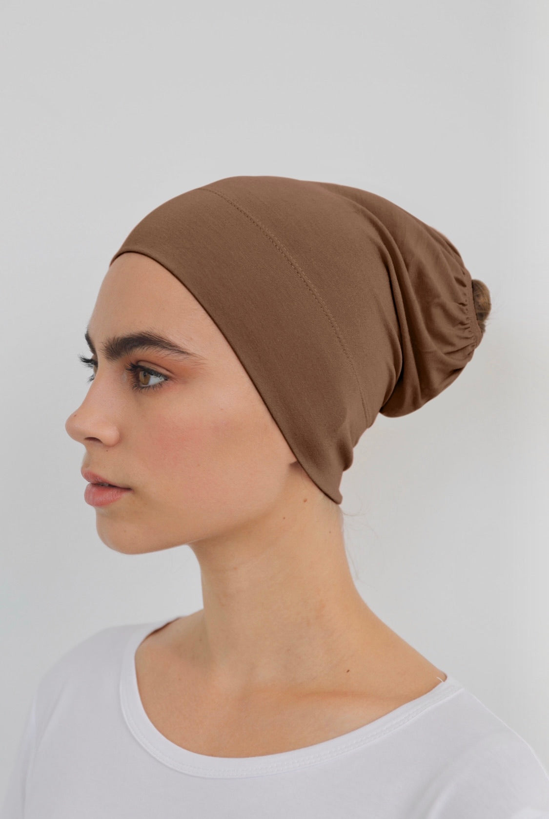 Bamboo under-scarf cap designed to cover hair beneath a hijab, made from soft, breathable natural bamboo fibers with cotton spandex stretch for comfort. Partially closed at the back with an elastic edge to comfortably accommodate hair.